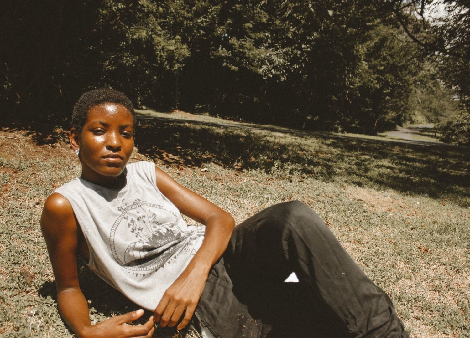 2022 hair trends: woman lying on the grass, with very short natural hair
