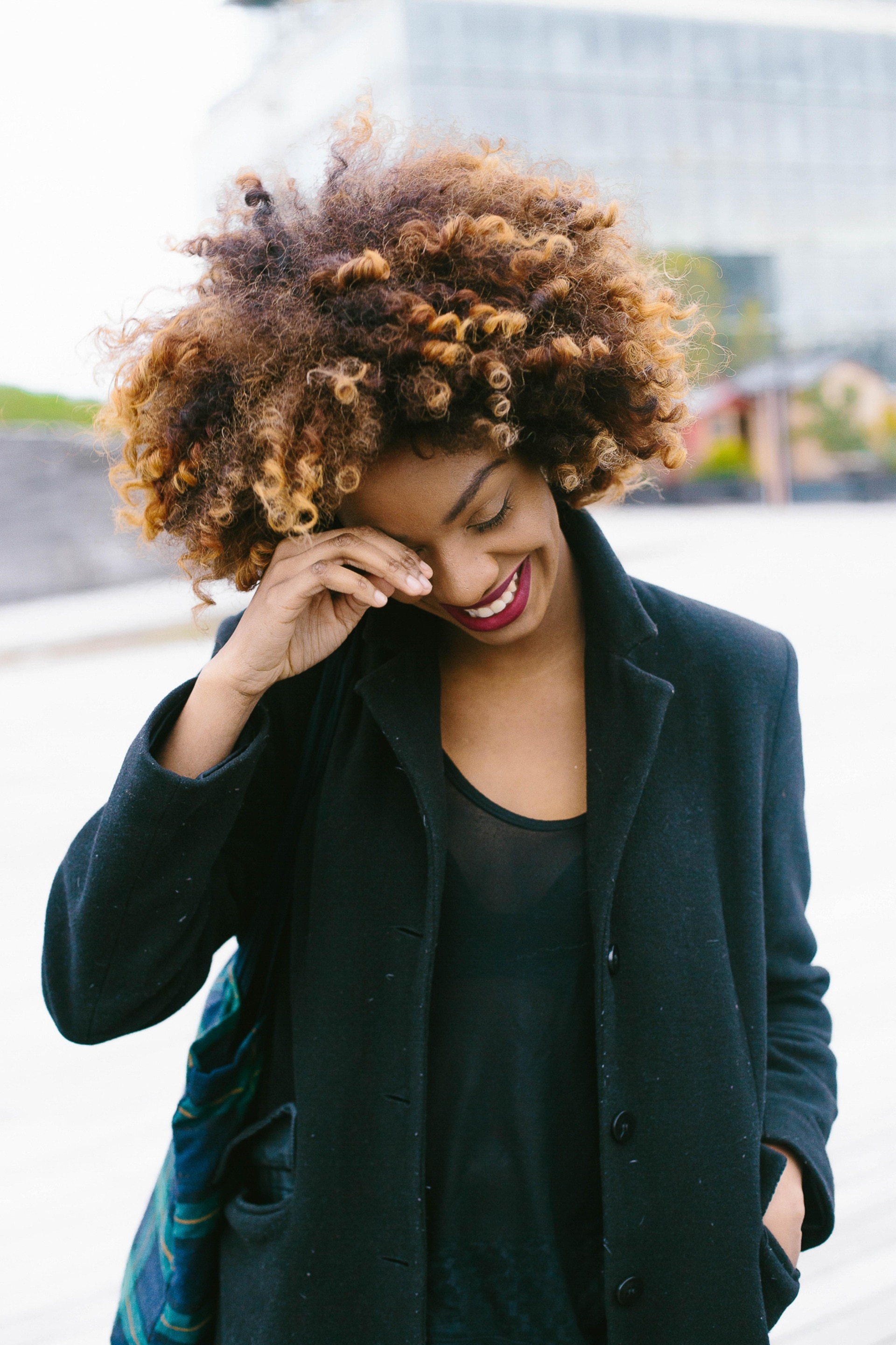 woman with afro curly hair caramel highlights