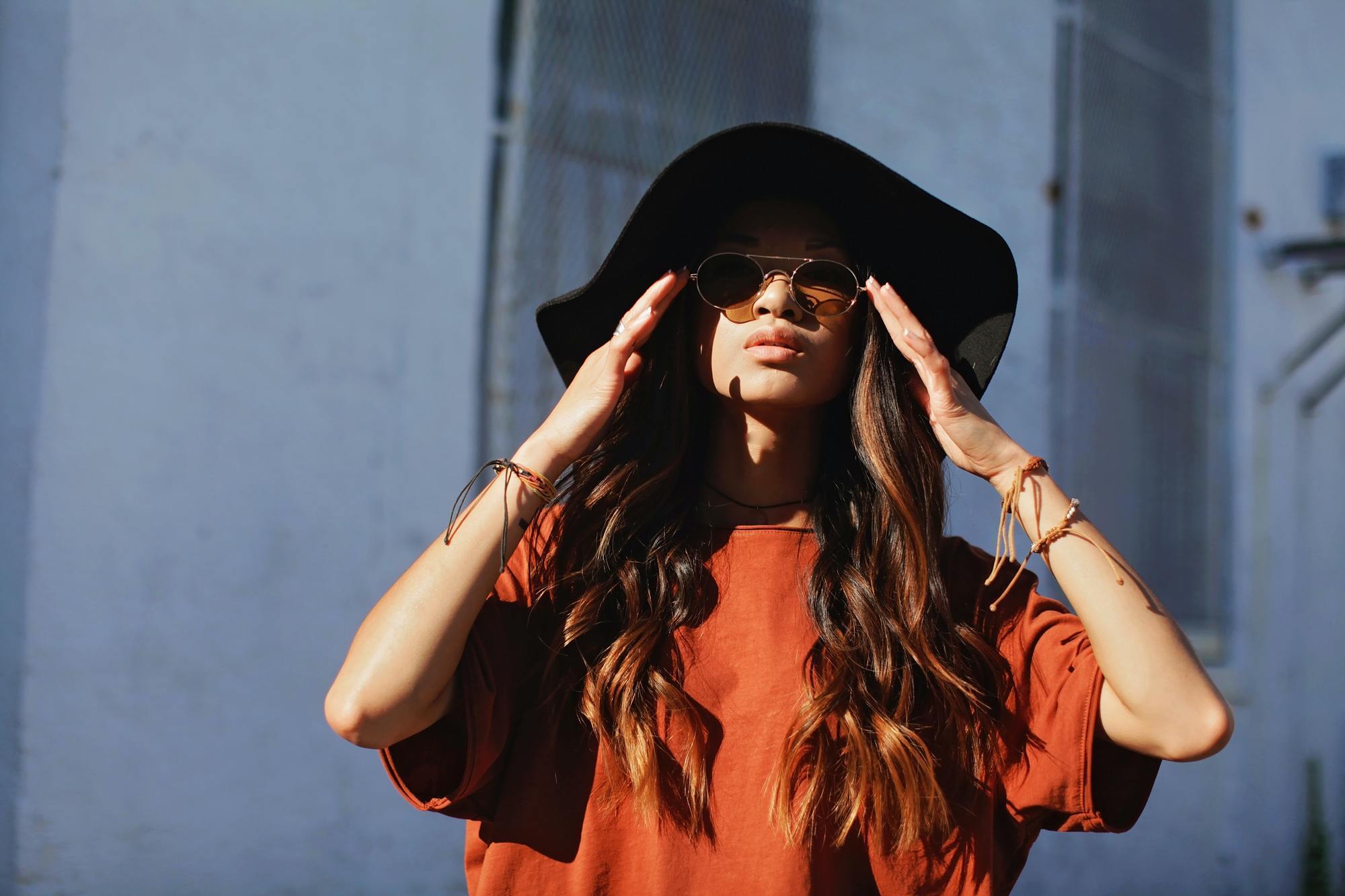 spring haircare routine: woman wearing a broad-brimmed, floppy black hat