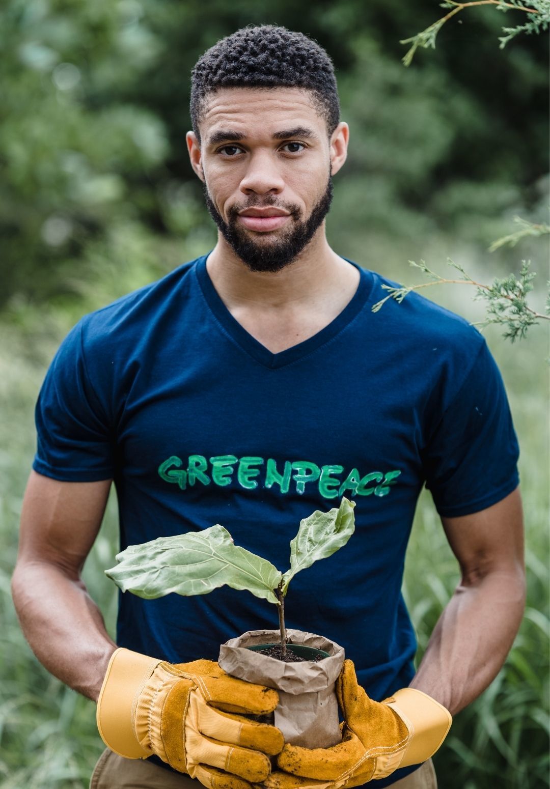 a man holding a pot plant with a small plant in it