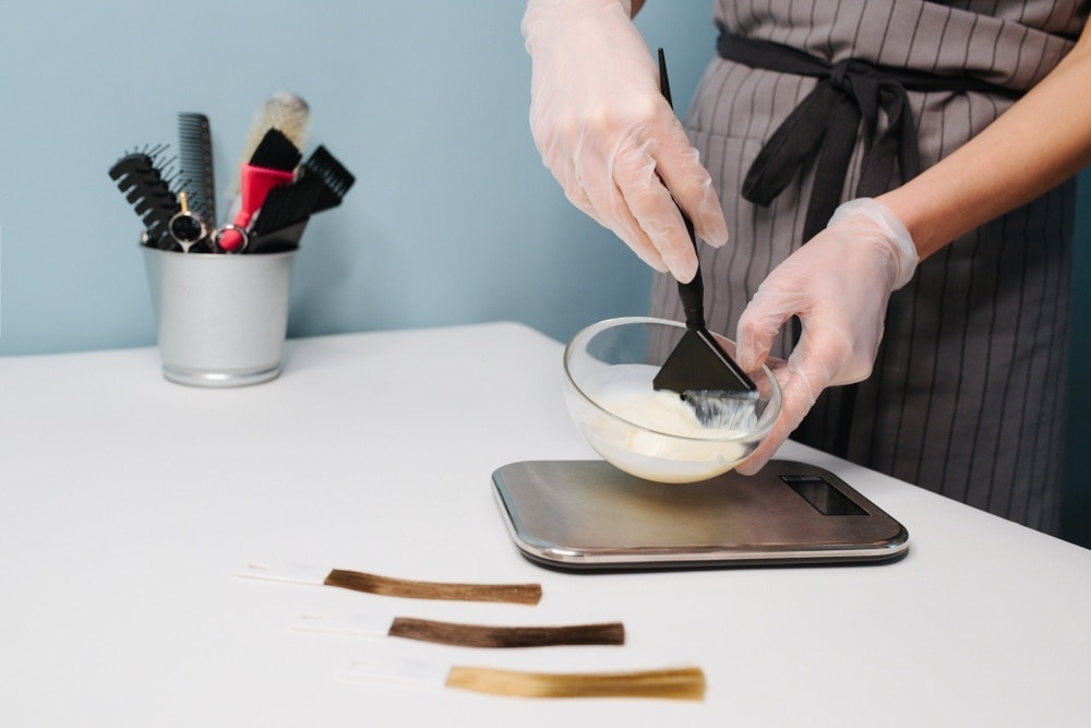 dye your hair at home: three swatches of hair and a mixing bowl with hair dye being mixed