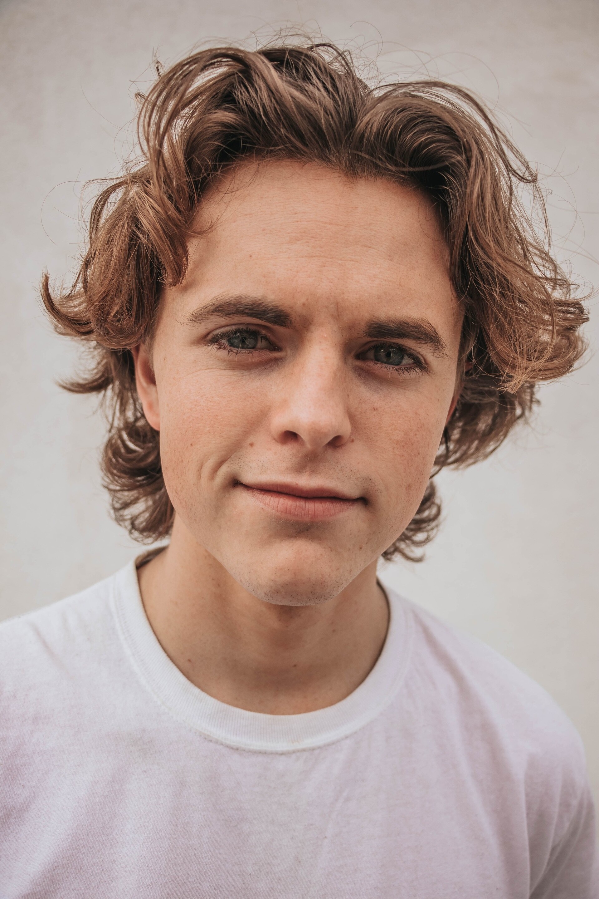 men's medium hairstyles: man with light brown, medium-length wavy hair