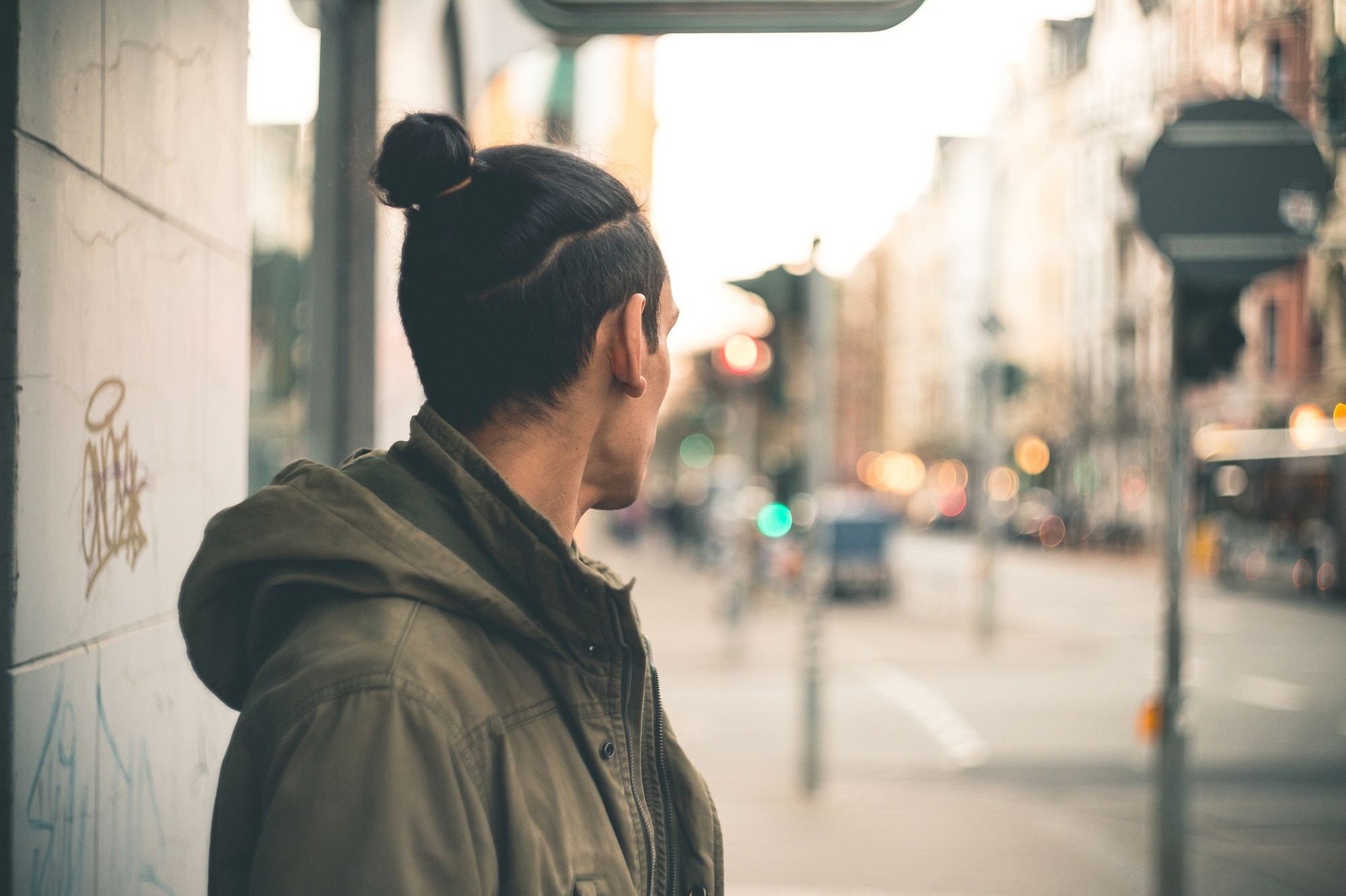 men’s medium hairstyles Man with topknot hairstyle and undercut