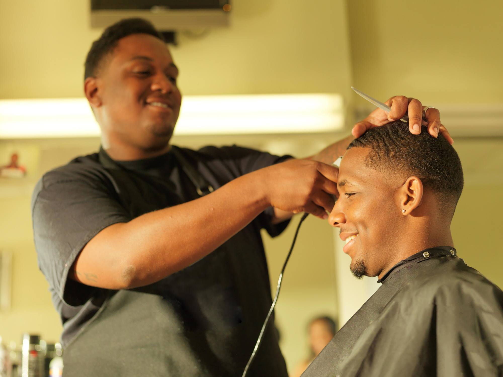 buzz cut hairstyles: man getting his hair cut at barber shop