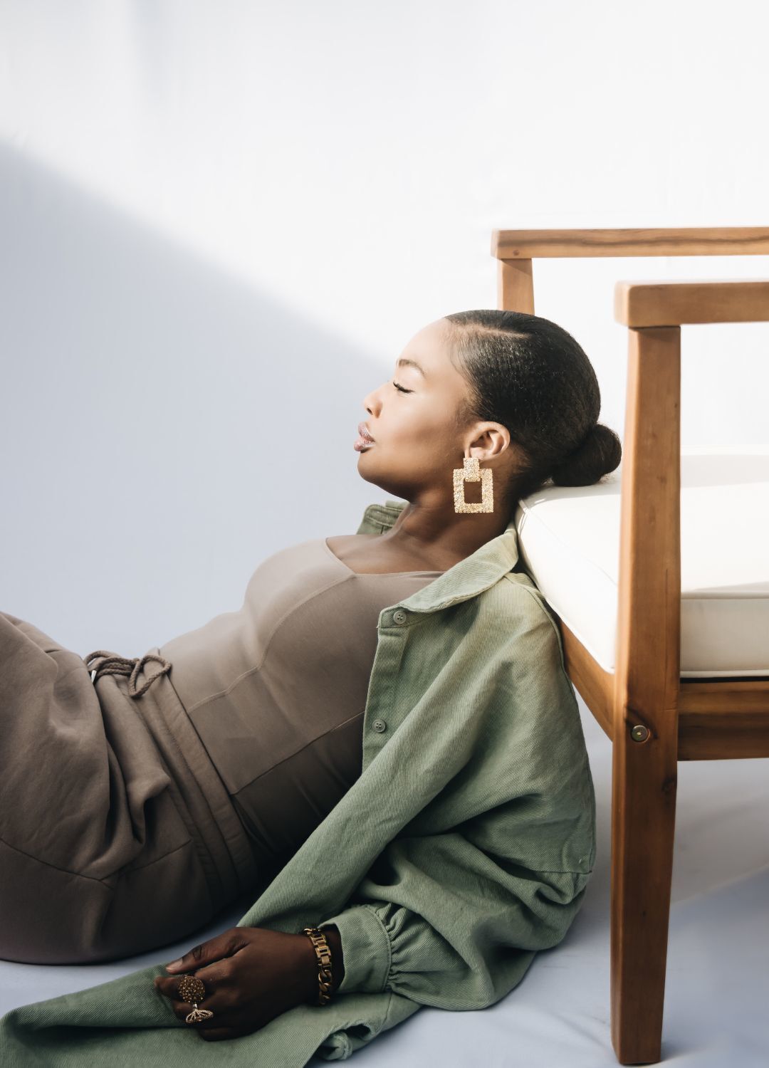 hairstyles for rainy weather: woman with her hair tied into a low, sleek bun with a side path