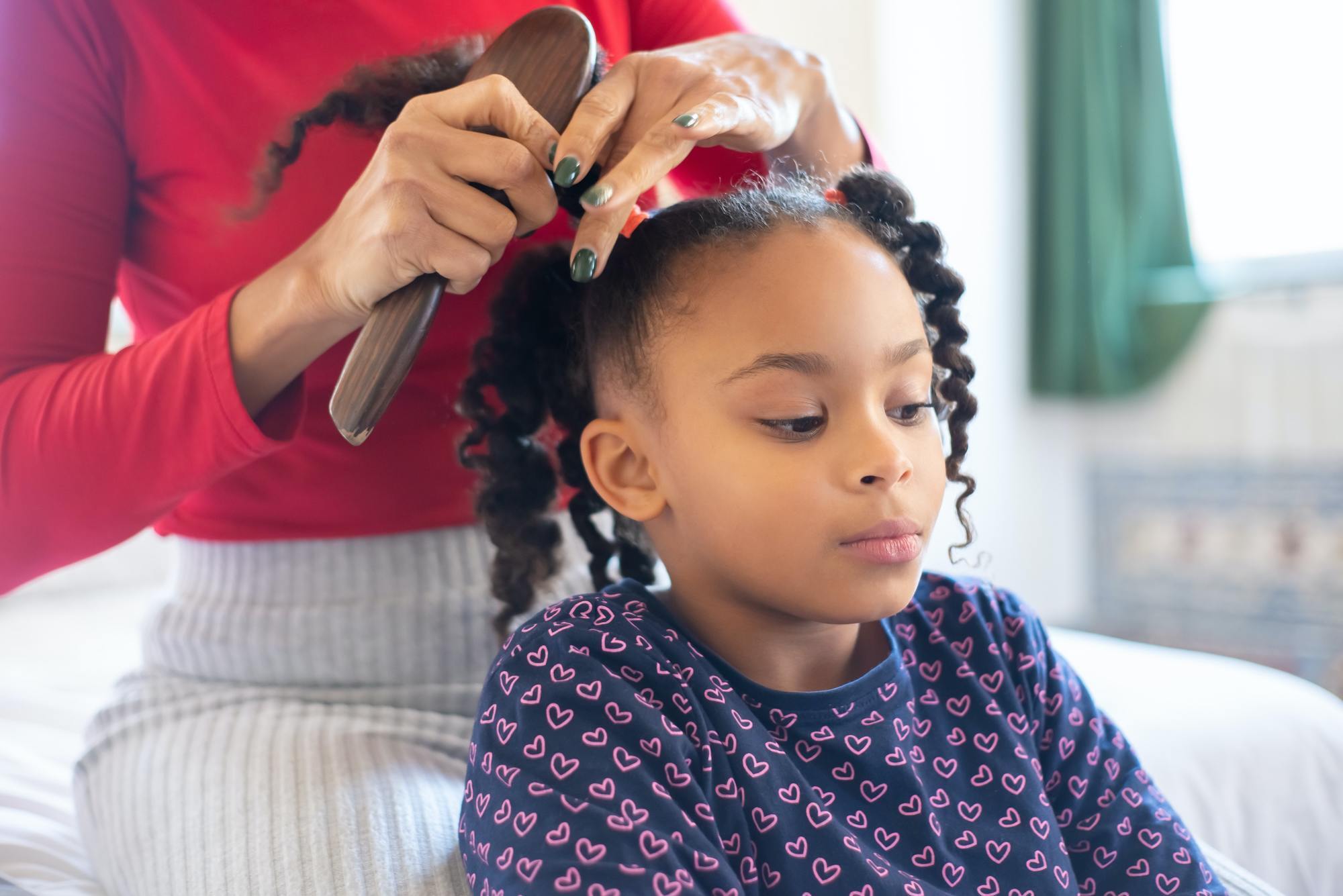 Little girl getting her hair brushed
