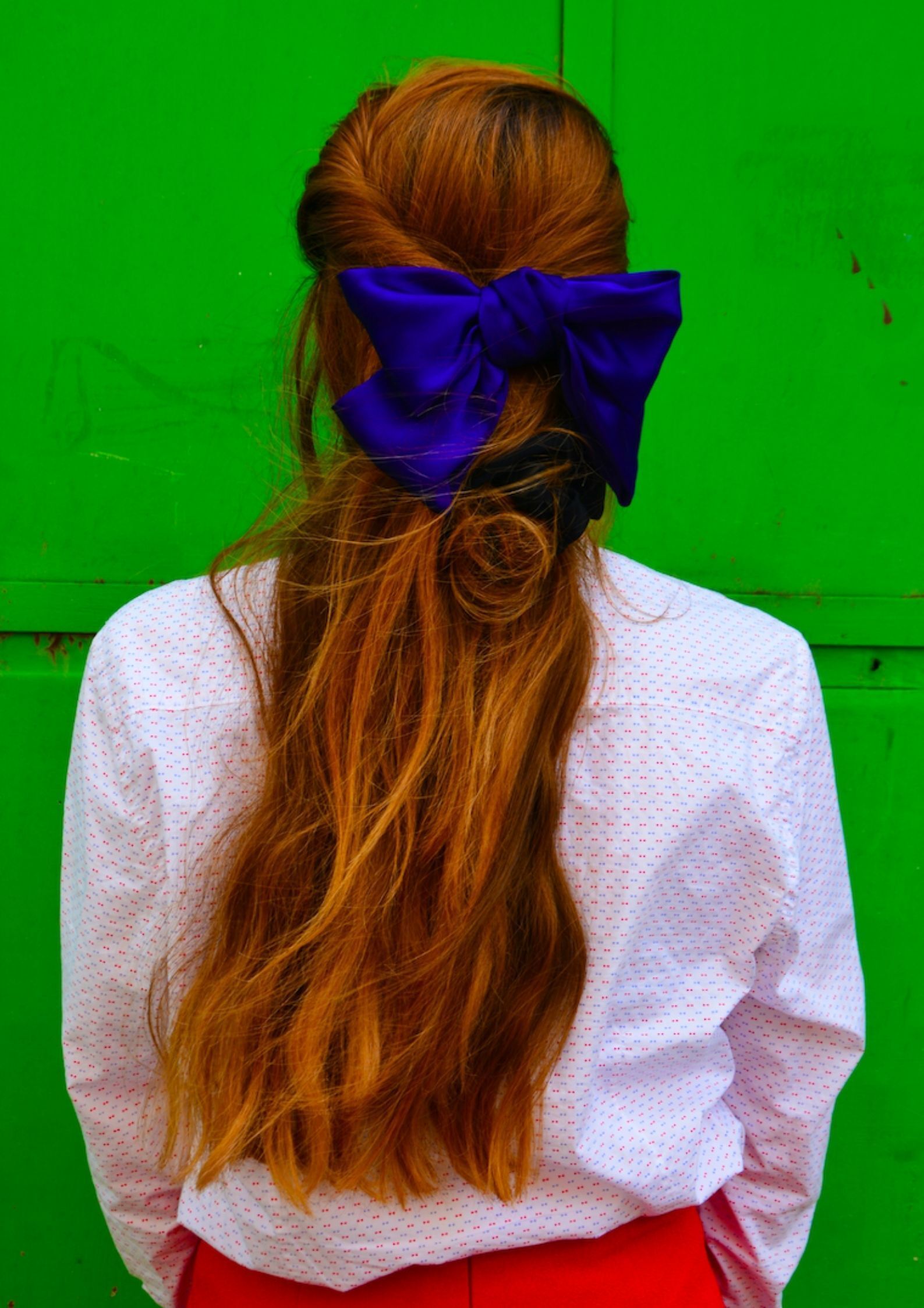 Woman with red hair wearing a big blue bow