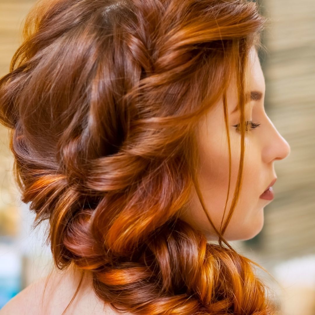 Woman with red hair wearing a side french braid