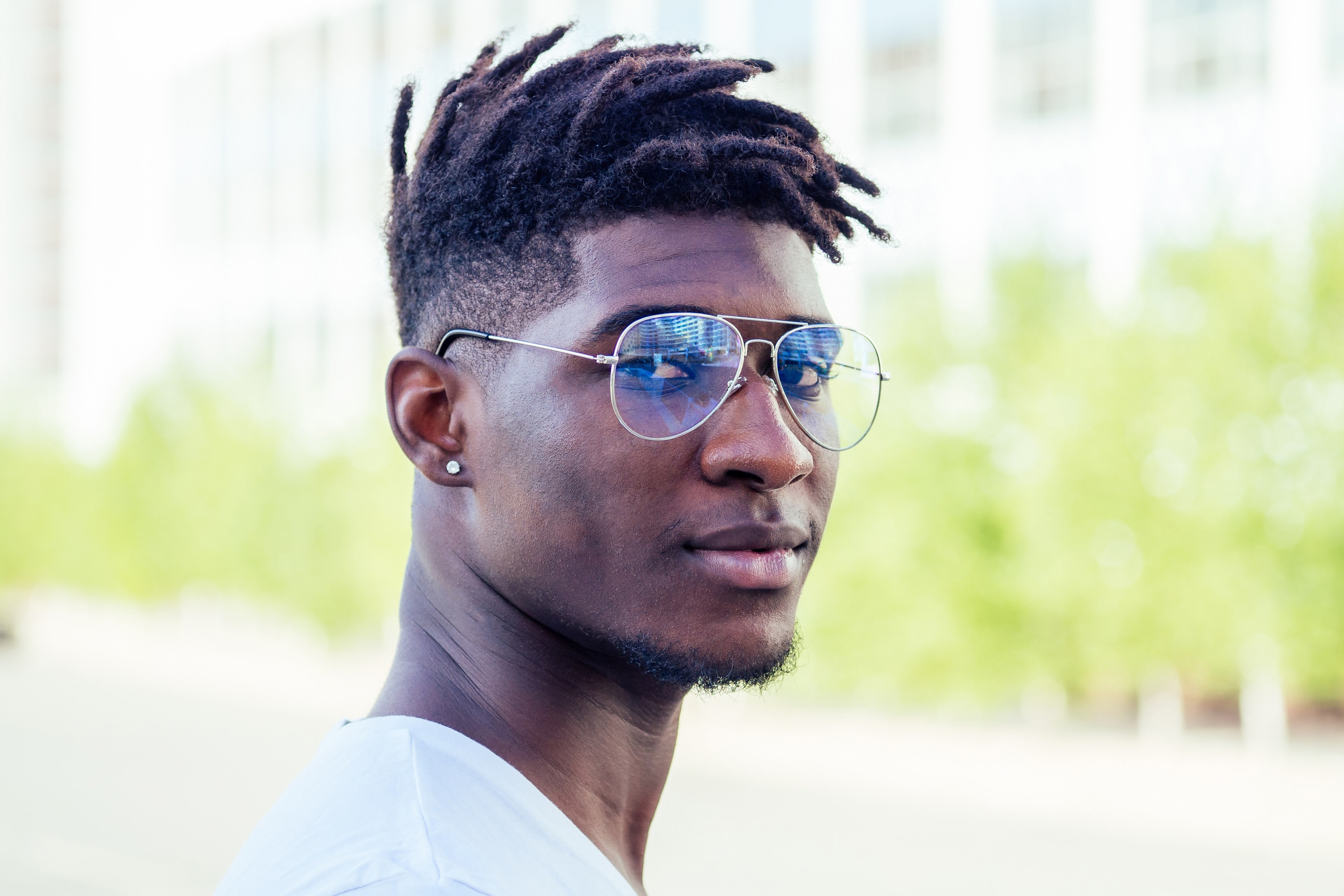 man with medium length locs on the top of his head and a fade haircut on the sides