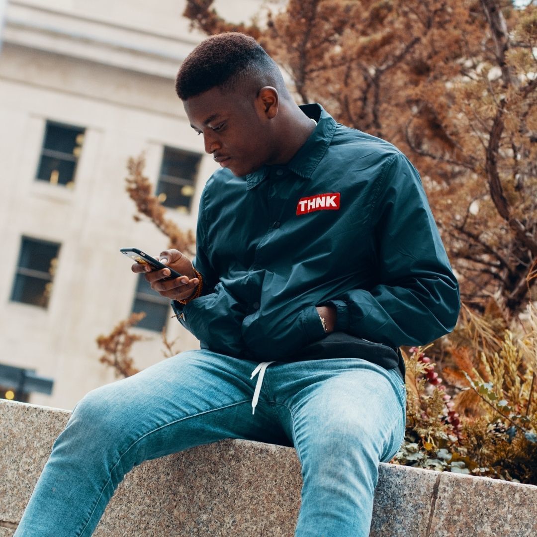 man with a fade haircut, sitting on a wall