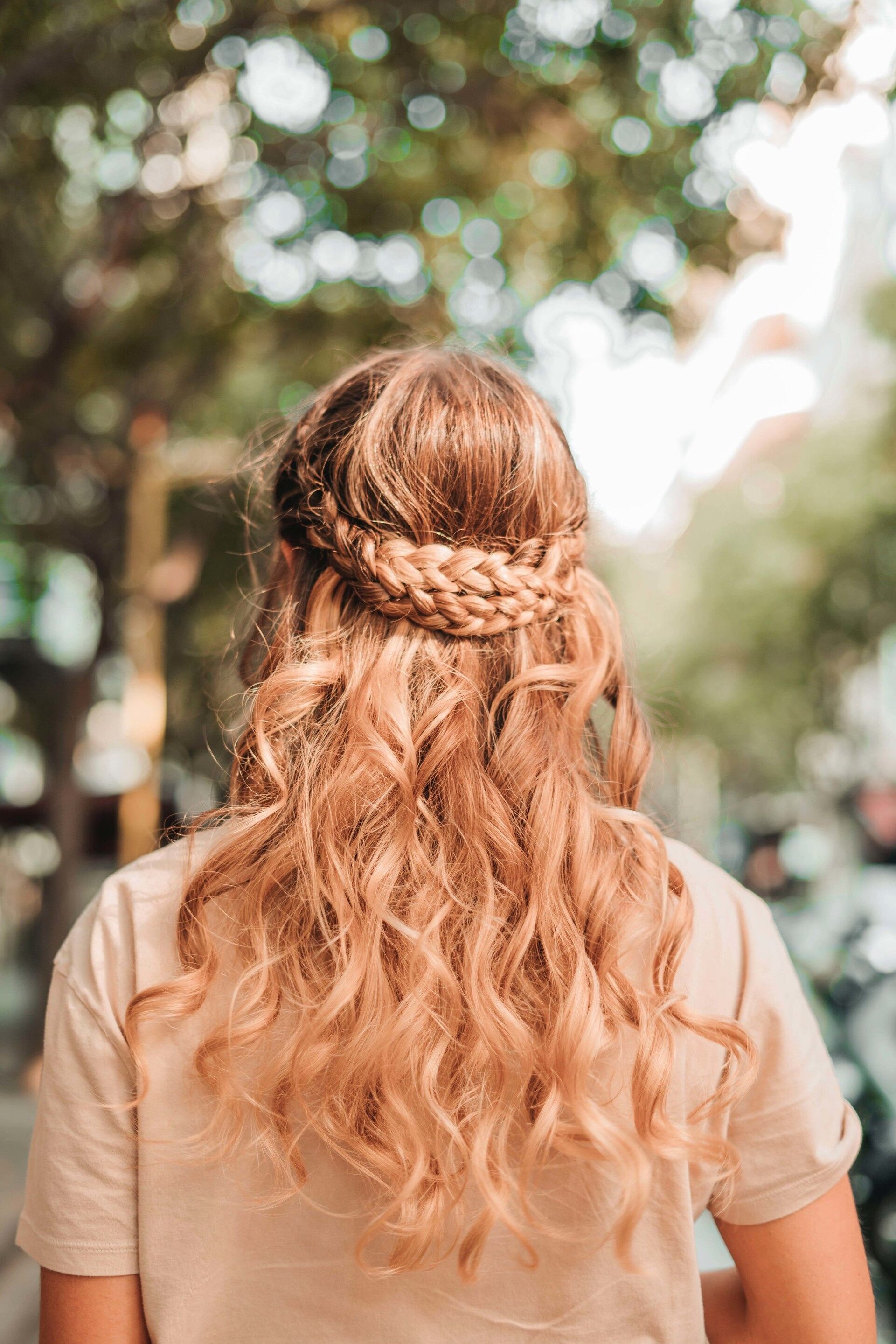 greek-inspired hairstyle: woman with long wavy strawberry blonde hair and a double braid