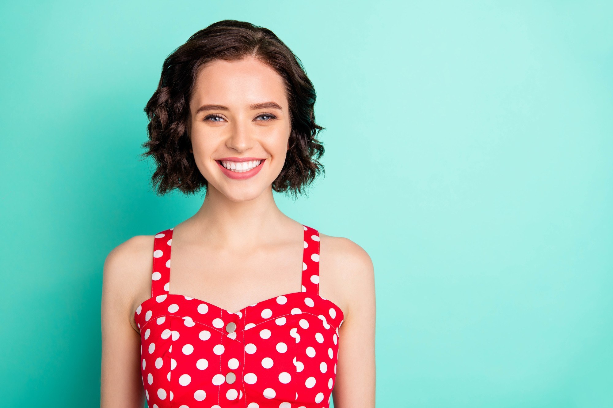 Hairstyles of great women: woman with jaw length dark brown curly hair with a side part