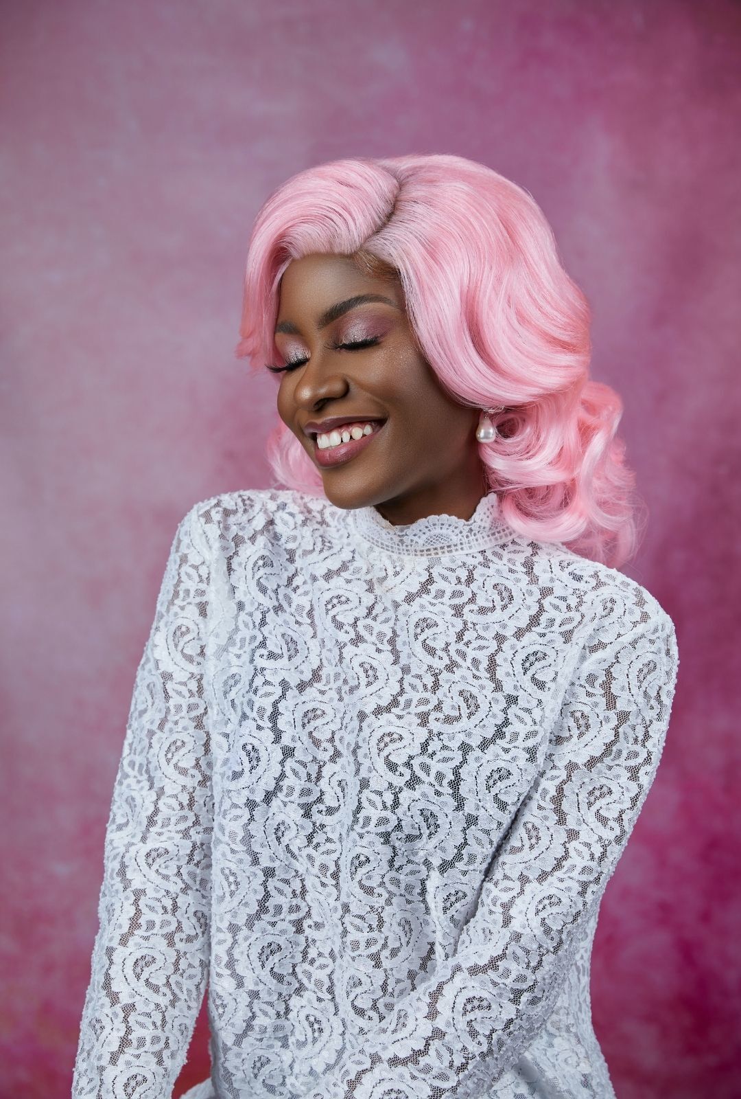 woman with pastel pink hair styled in glamorous waves