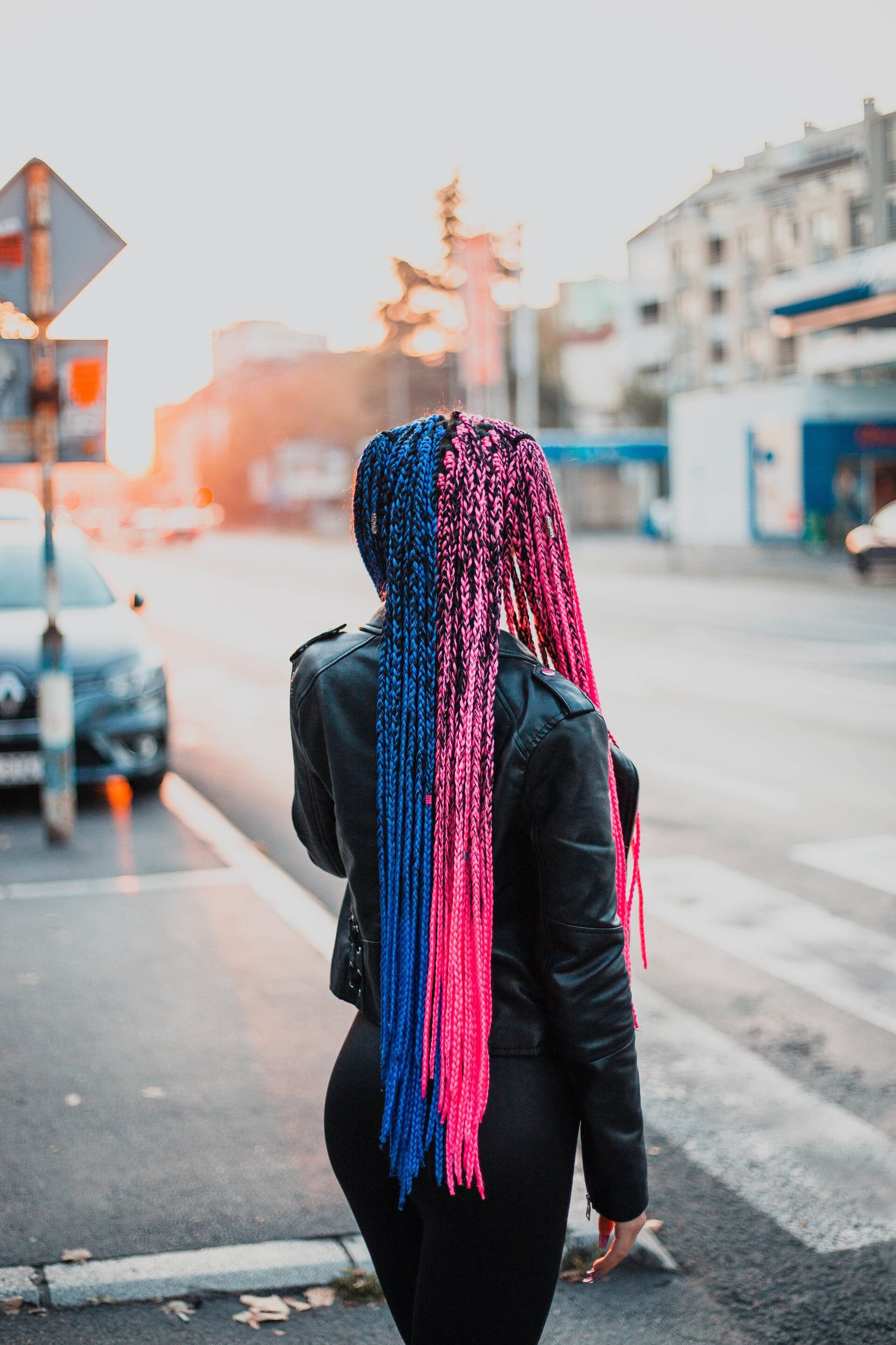 woman with very long braids; half the braids are blue and half the braids are pink