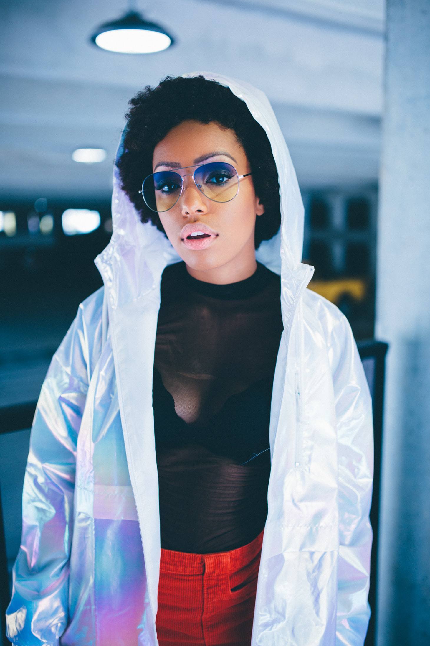 loadshedding hairstyles: woman with a medium-sized natural 4c afro, wearing a white jacket with a hood