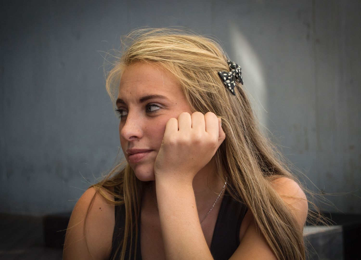 girl with long blonde hair, with a black polka dot bow clipped onto her hair