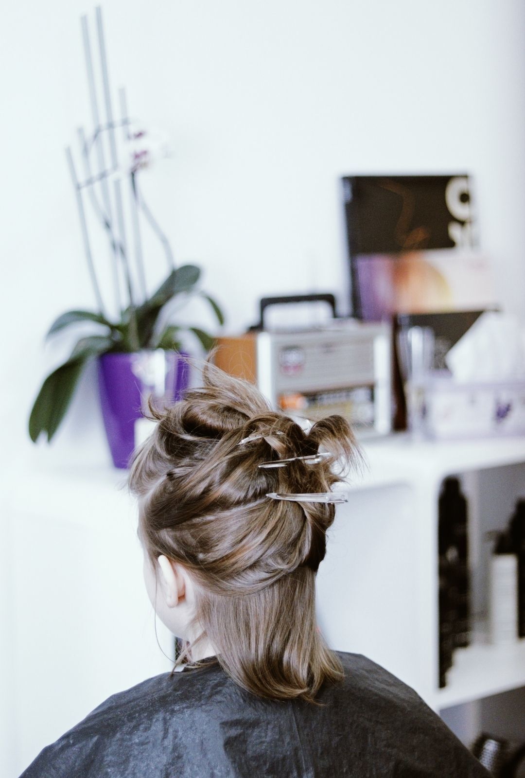 curl your hair: woman in a salon with many clips in her hair
