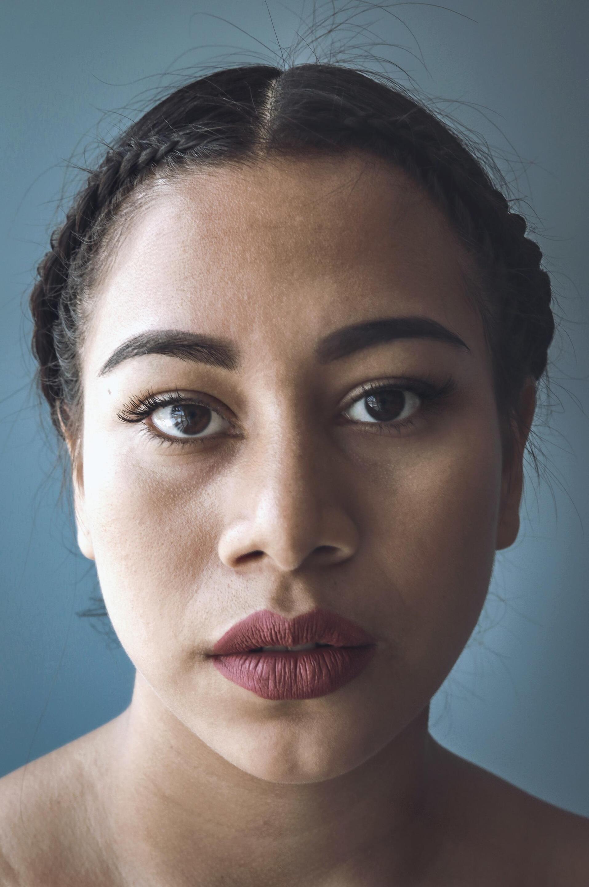 gym hairstyles for short hair: woman with dark brown hair with a dutch braid, braided close to the front hairline