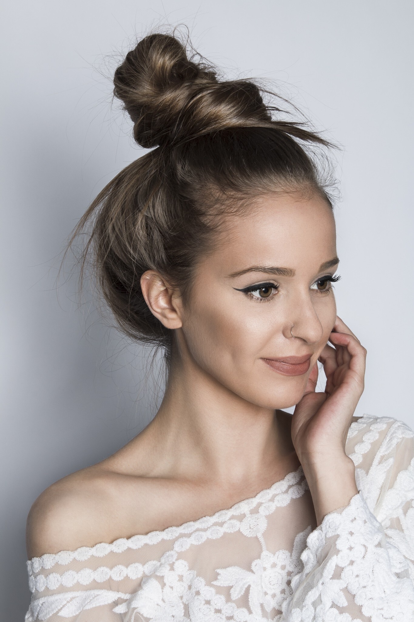 damage caused by styling: smiling girl for damaged hair messy bun
