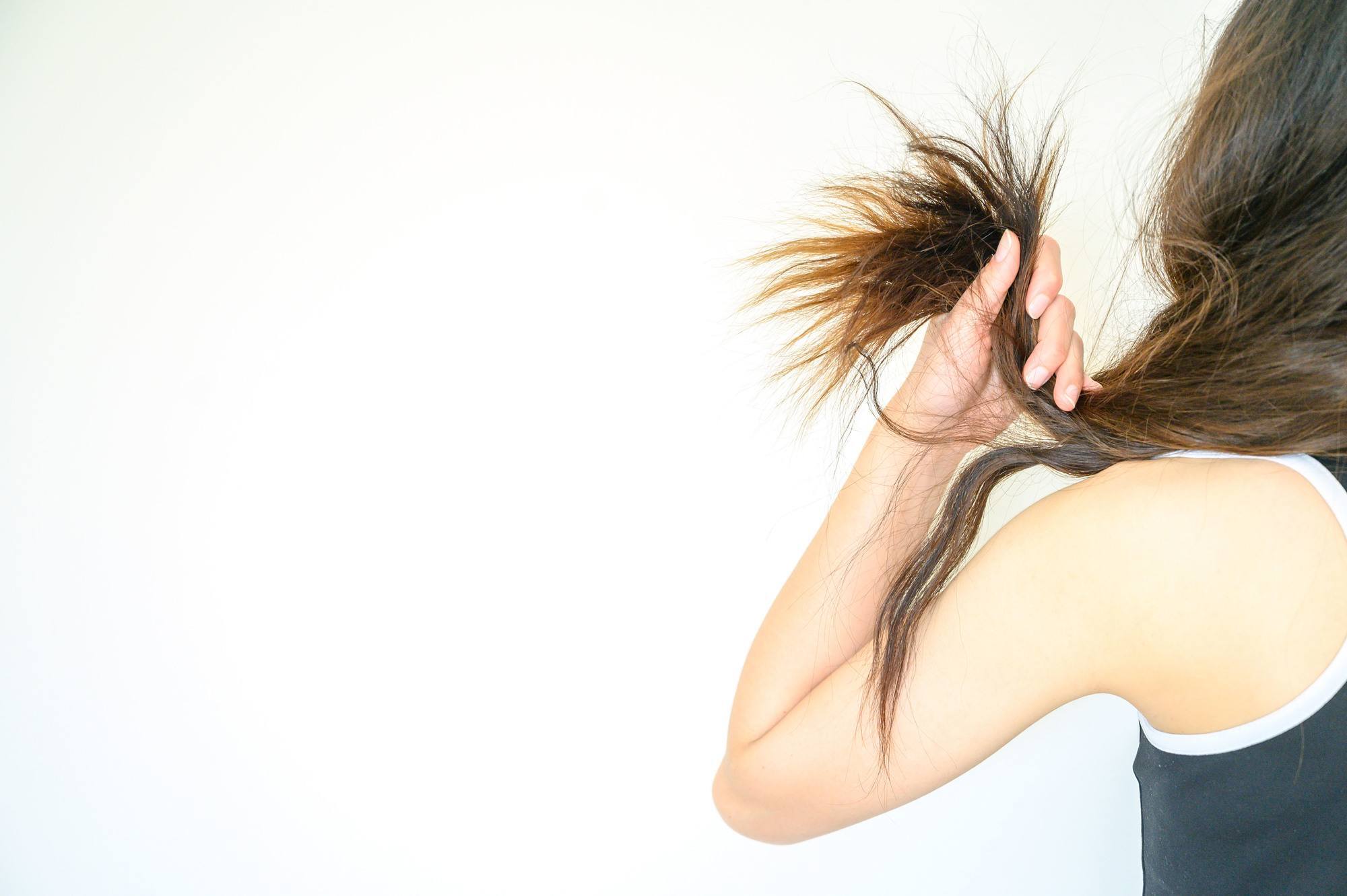woman holding dry, damaged hair