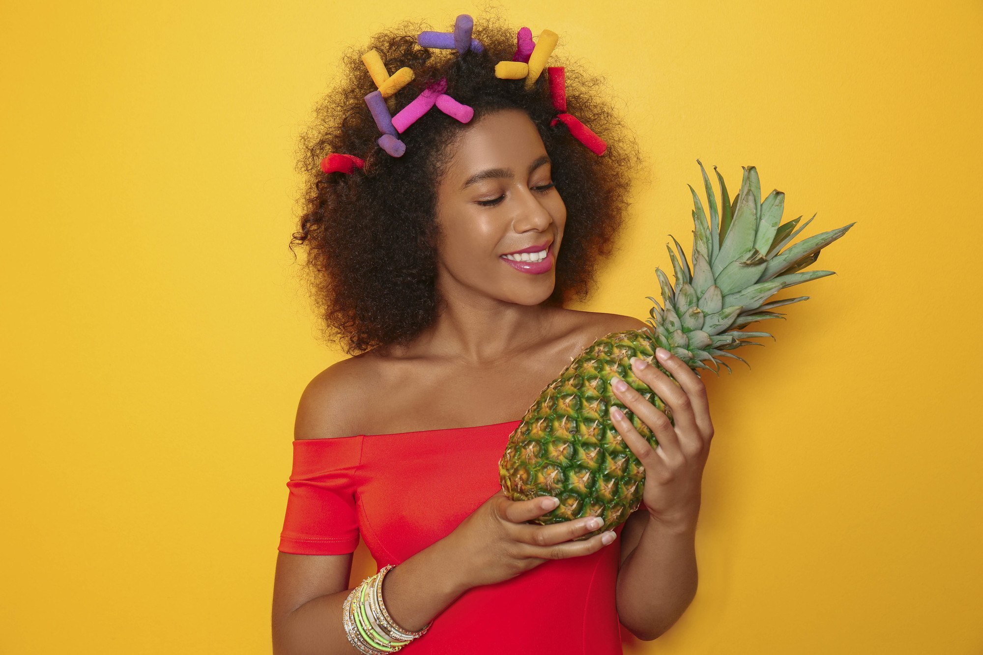 black woman with flexi rods in her afro hair for heatless styling