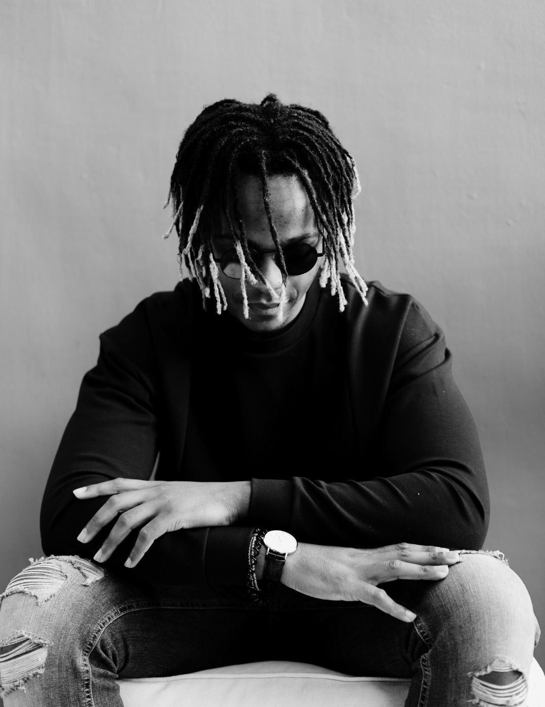 hair stories: black and white image of a man with medium-length locs with blonde tips