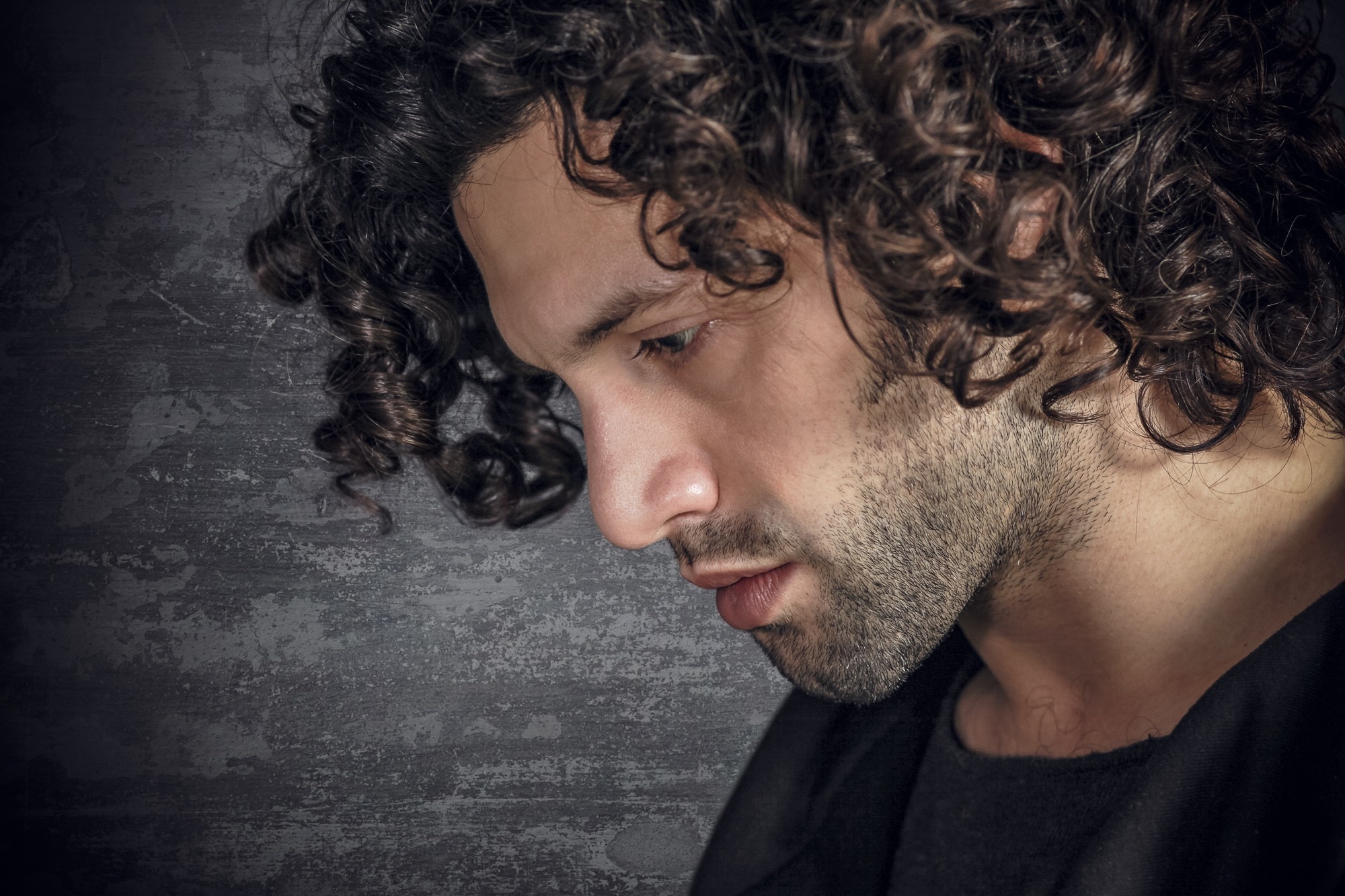 closeup of a man with medium curly hair tight curls