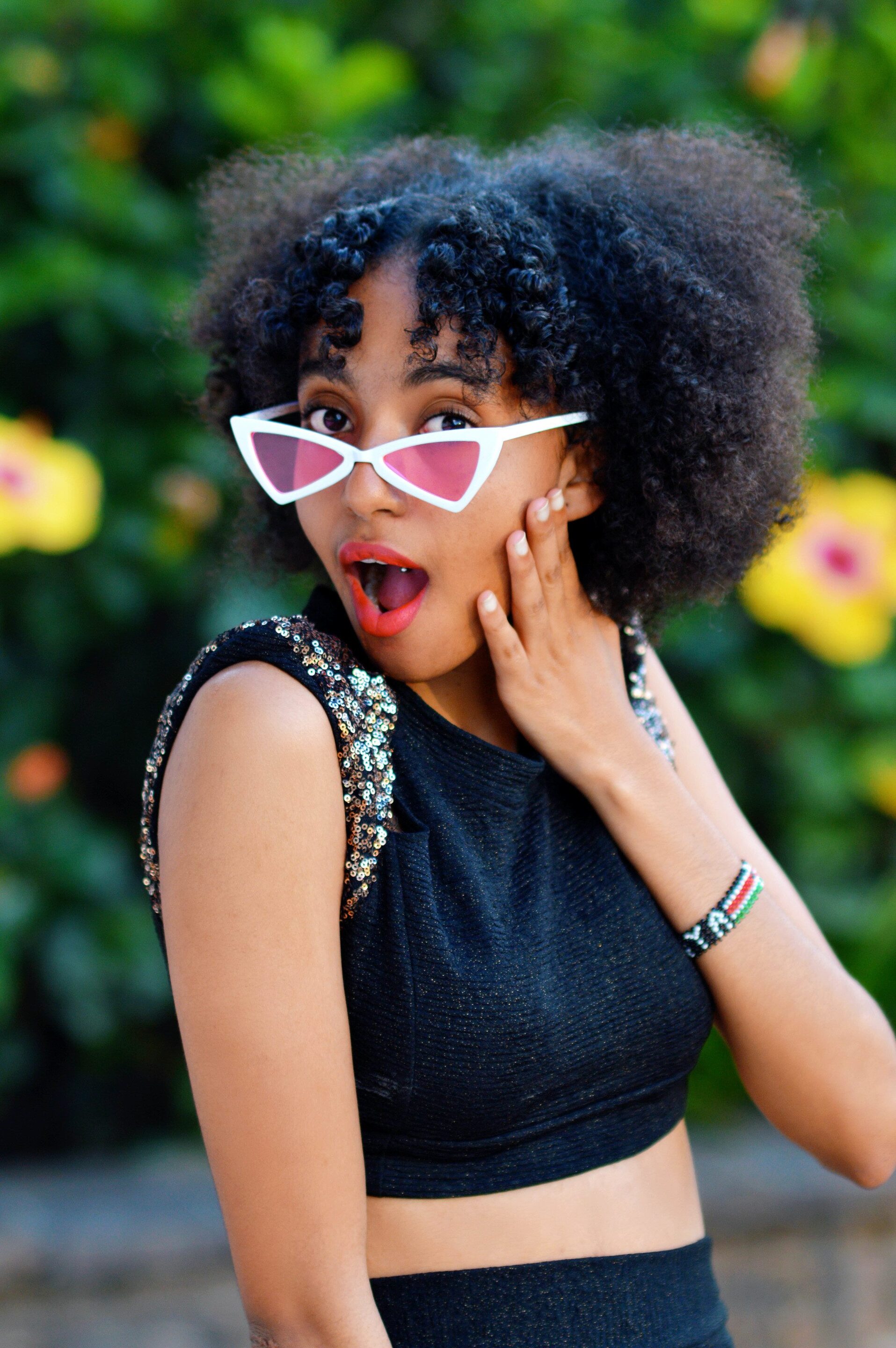 Cancer zodiac: woman with natural 4C hair styled into an afro with a middle path and a fringe