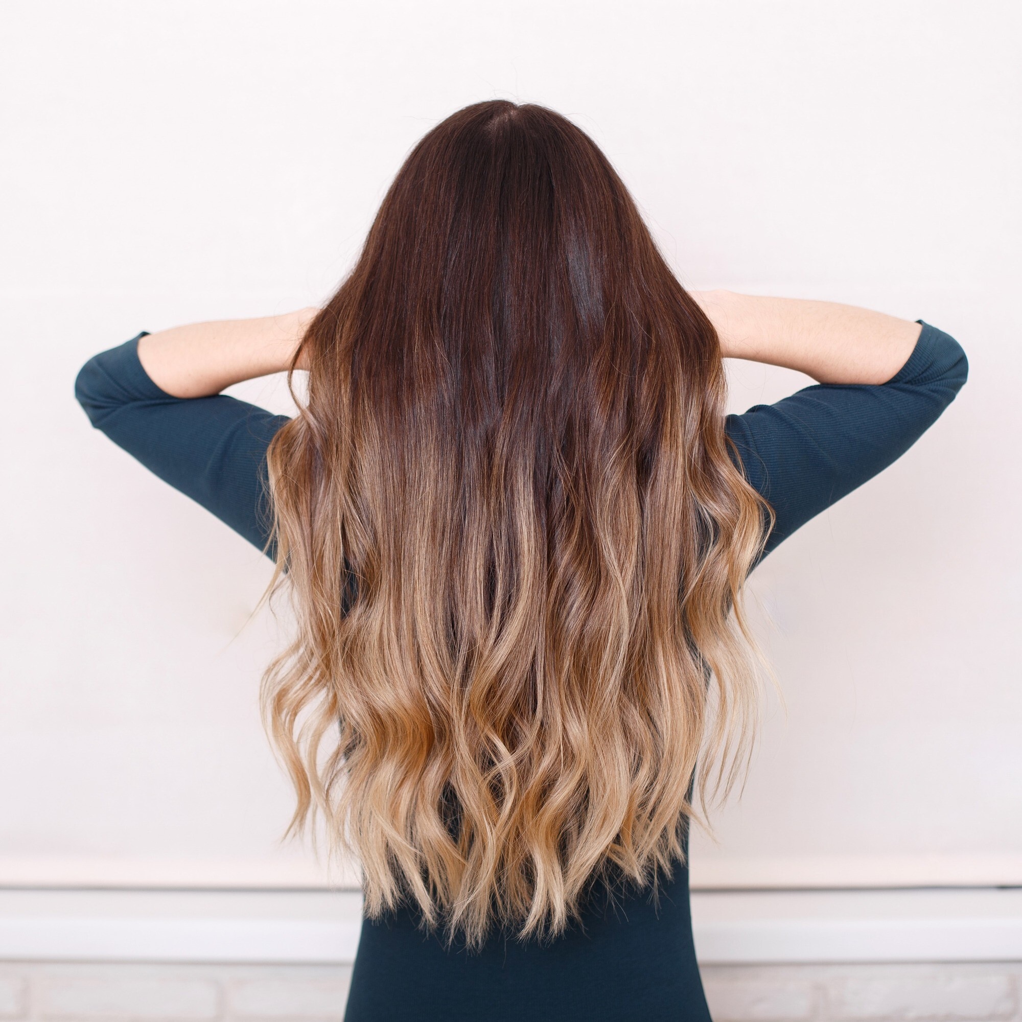 focus on long wavy brown hair; the top half dyed dark brown that fades into a light brown from halfway to the ends