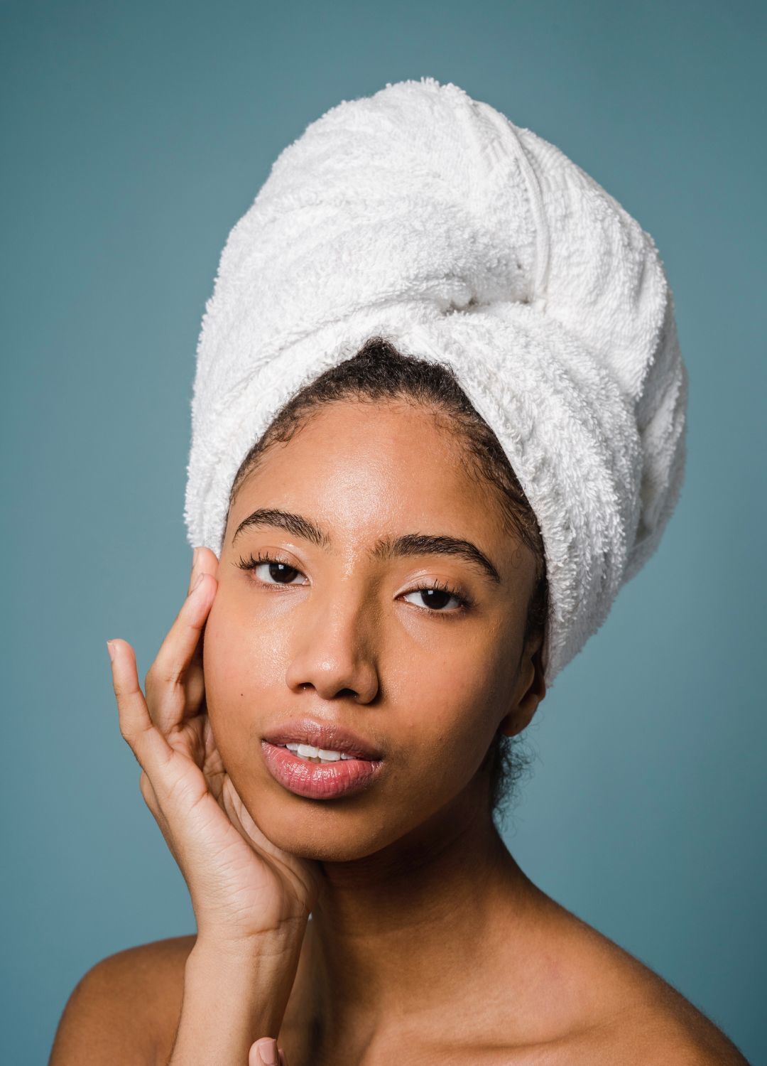 woman with a towel on her hair, loosely wrapping her hair