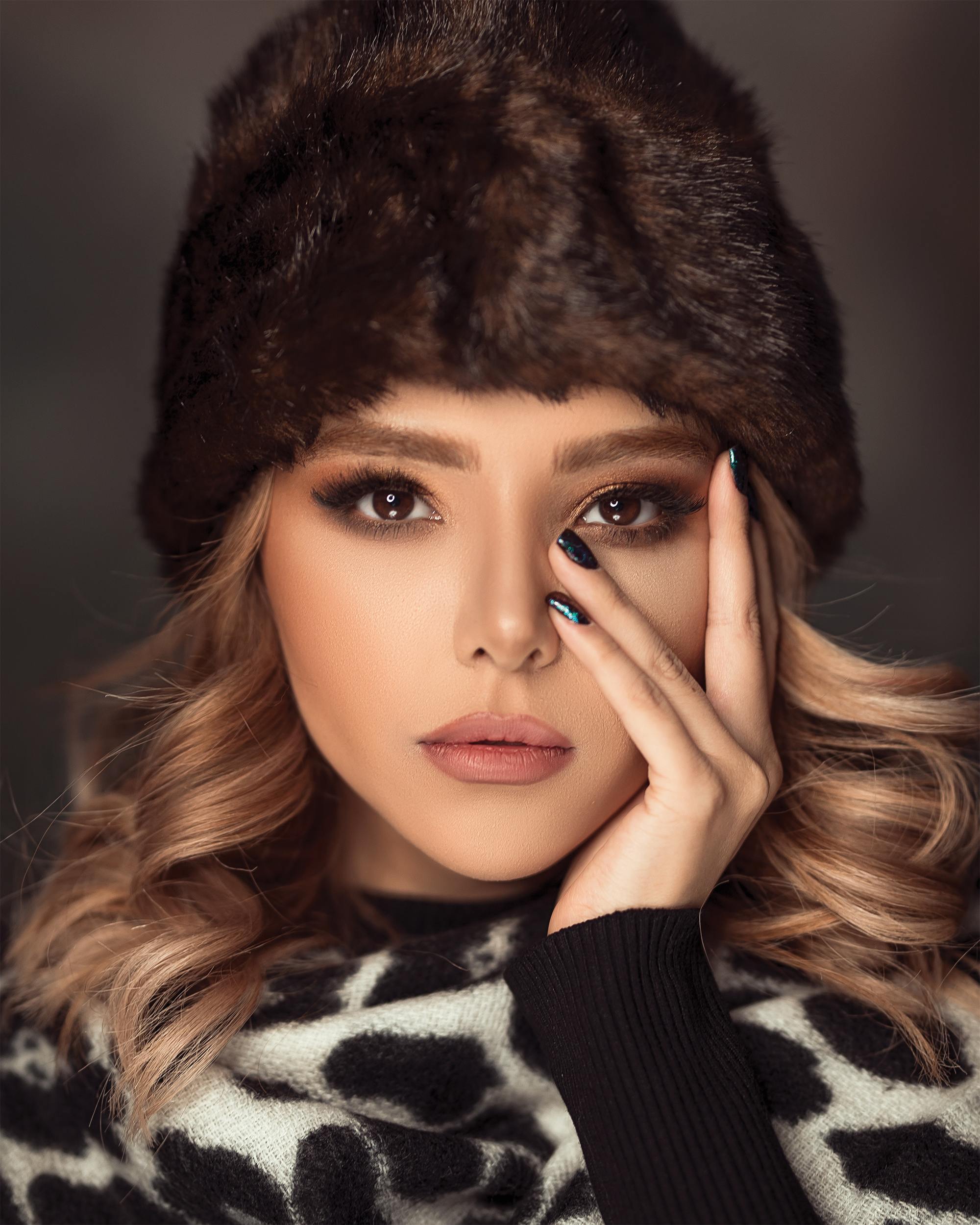 hair accessories: woman with light brown/dark blonde hair in elegant curls, wearing a fluffy winter cap