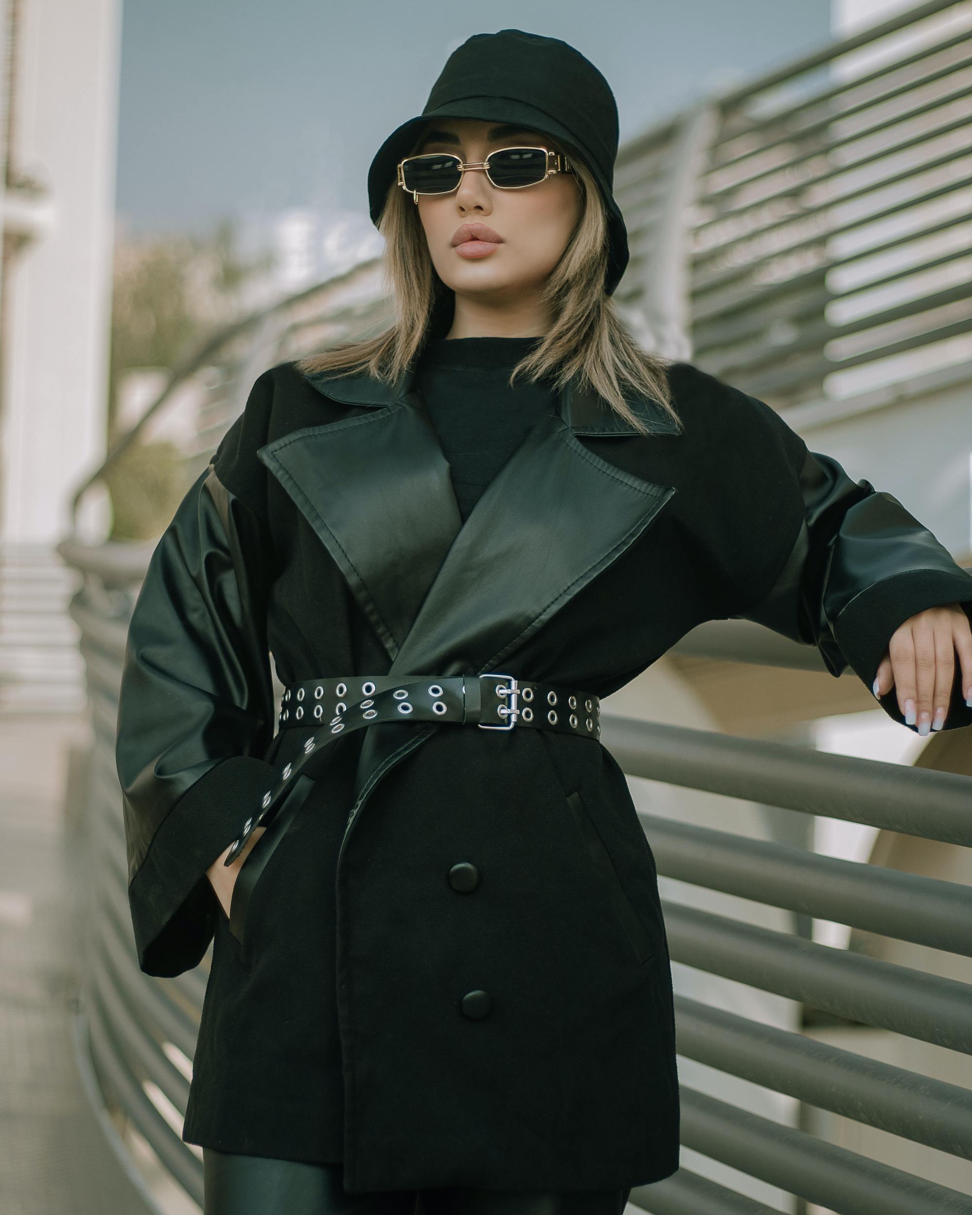woman wearing dark glasses and a thick winter coat, with a black bucket hat