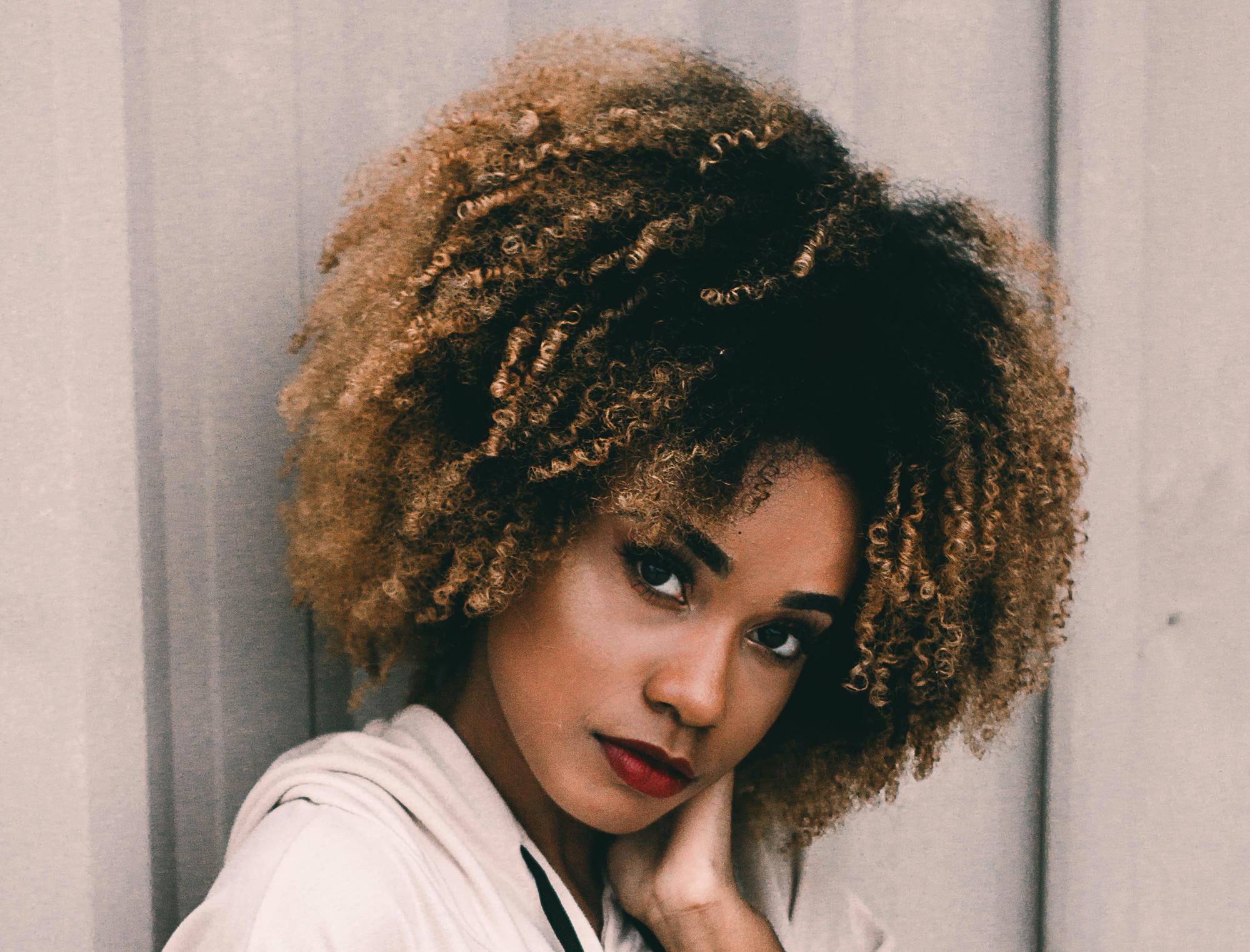 types of hair colour: woman with voluminous natural hair and highlights