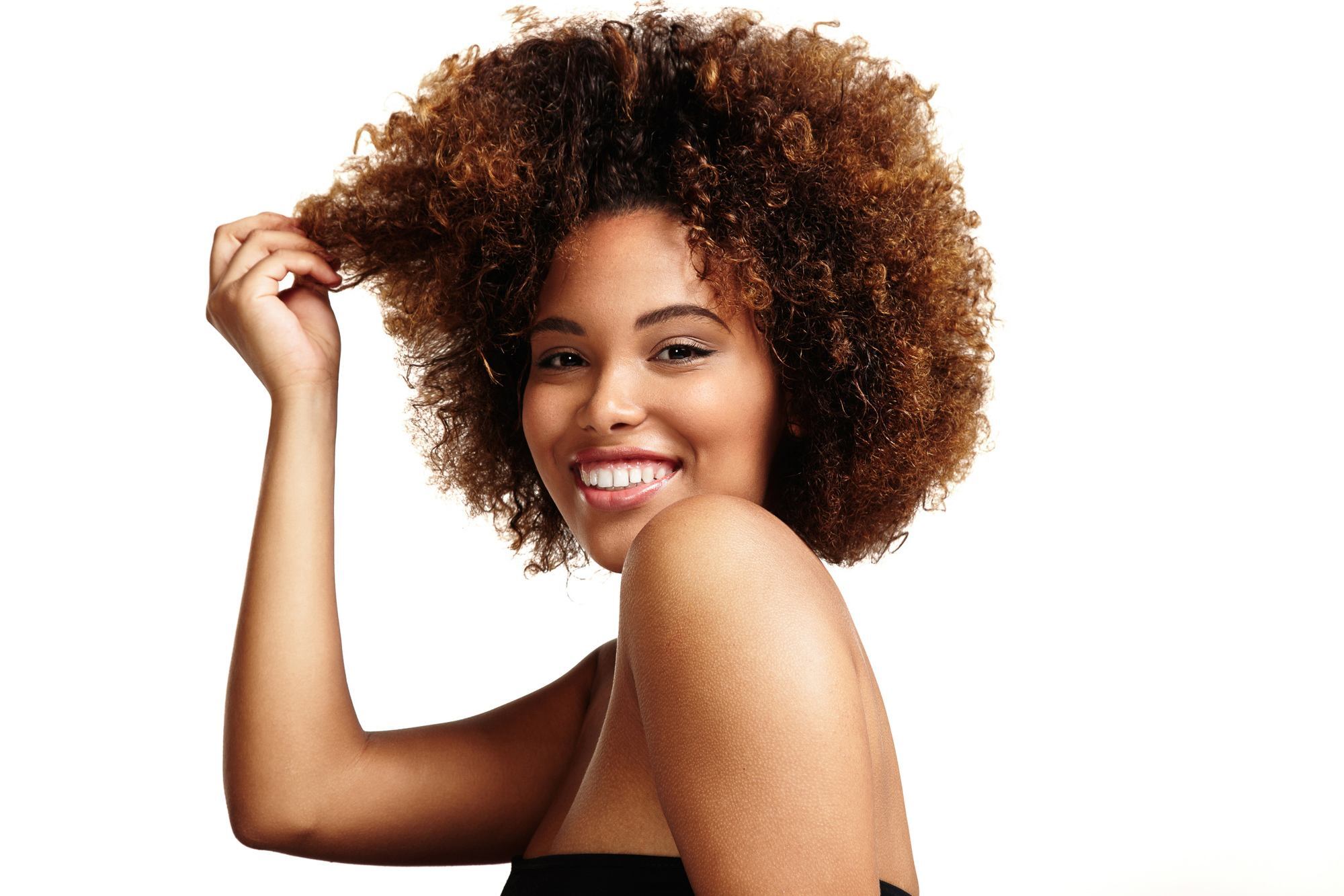 woman with short 4A type hair natural curls brown highlights ombre