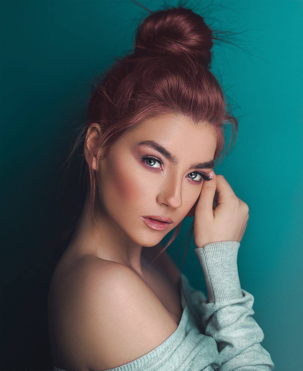 woman with dark auburn burgundy hair sleek messy topknot modern goth hairstyles