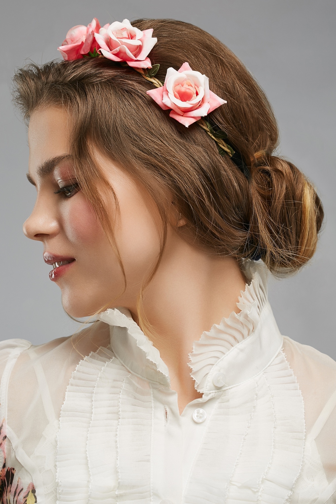 woman with low bun hairstyle flowers in hair