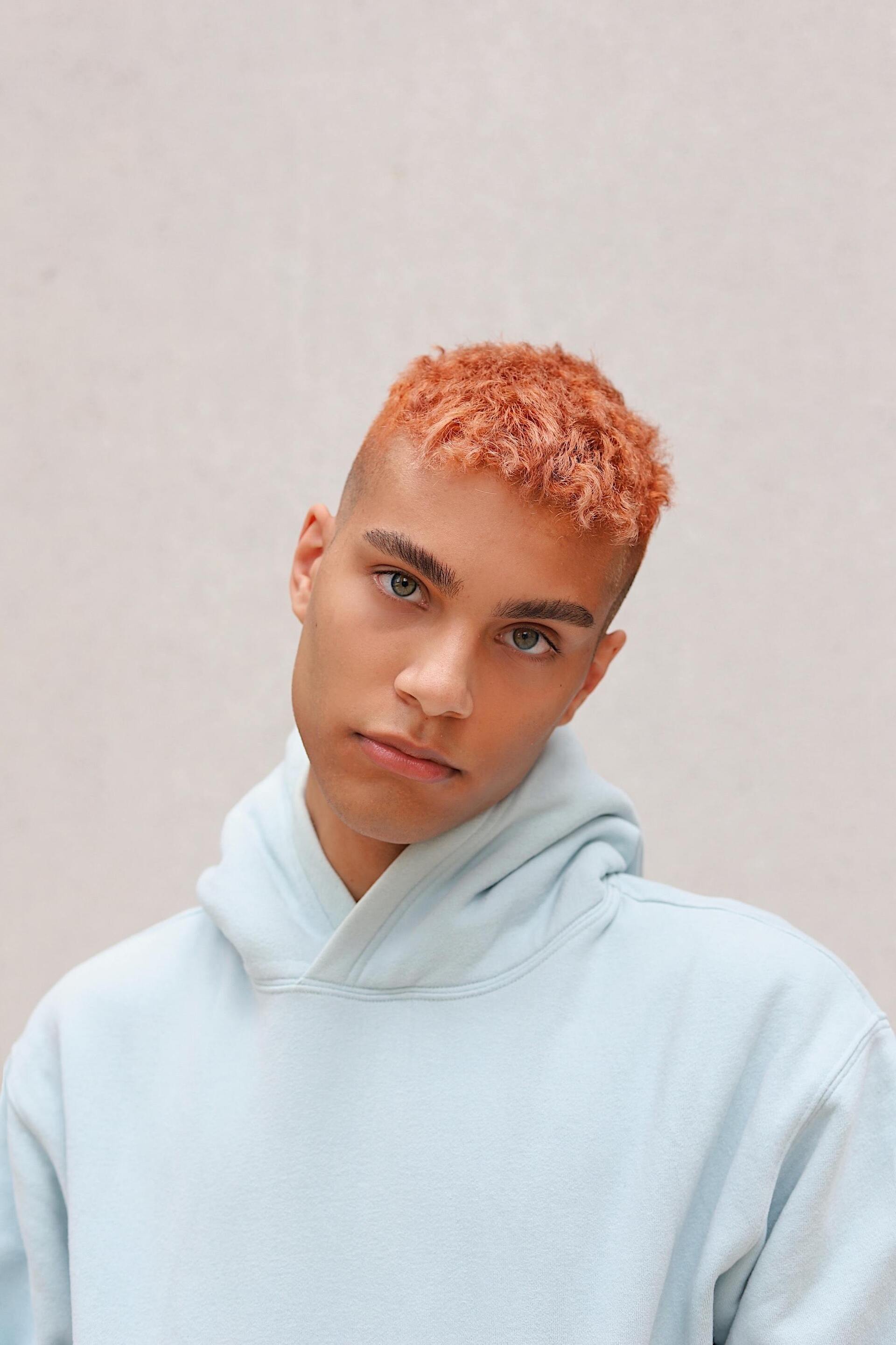 TikTok hairstyles: man with very short pastel pink hair