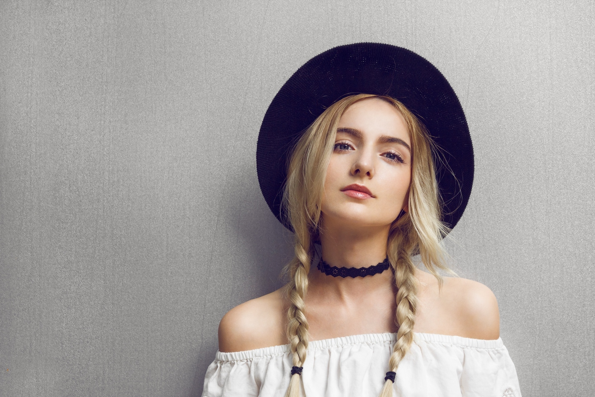 woman with wide brimmed hat and pigtails braids