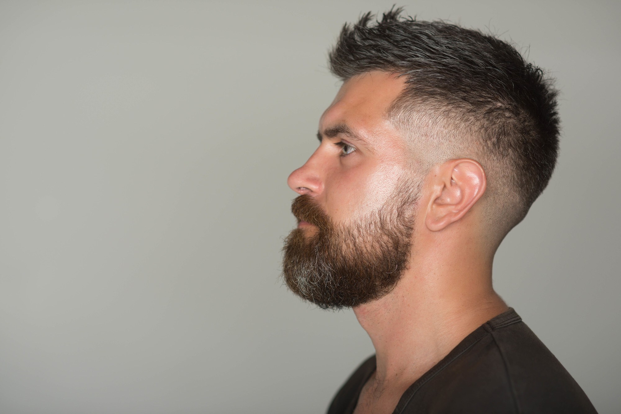 man with a quiff hairstyle and fade, with a big beard