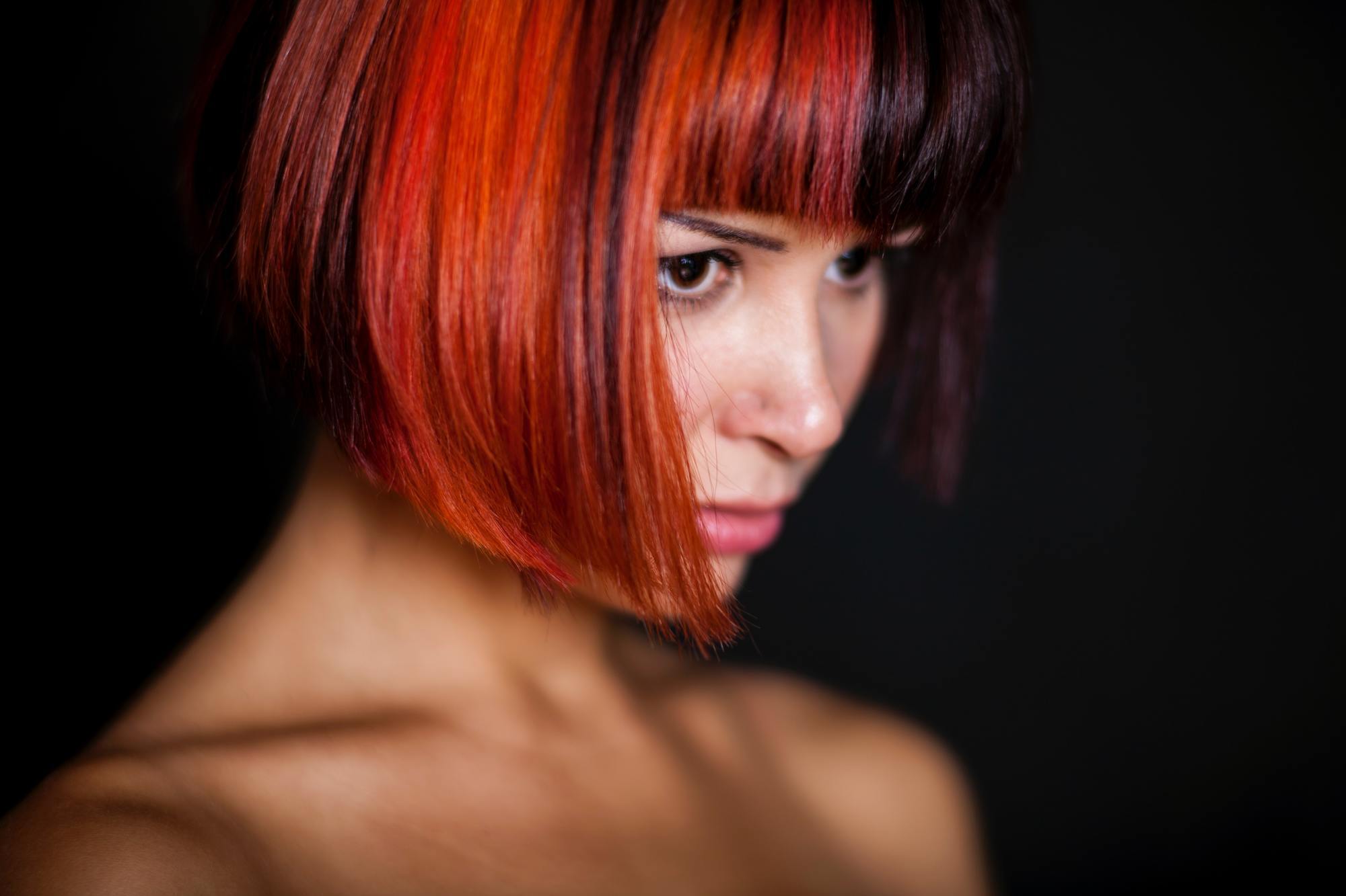 woman with a bob haircut, half dyed red and half dyed black