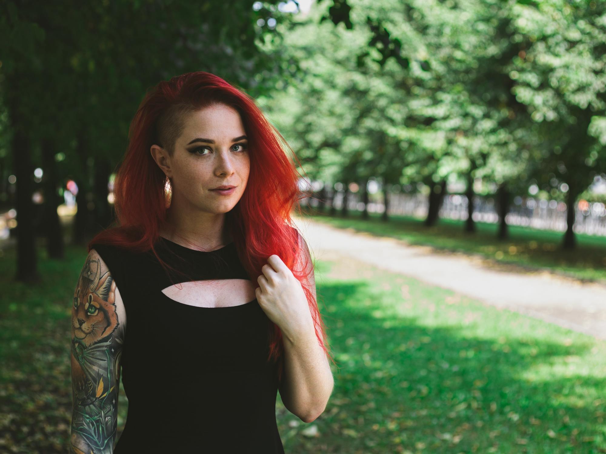 woman with bright red hair and a black undercut
