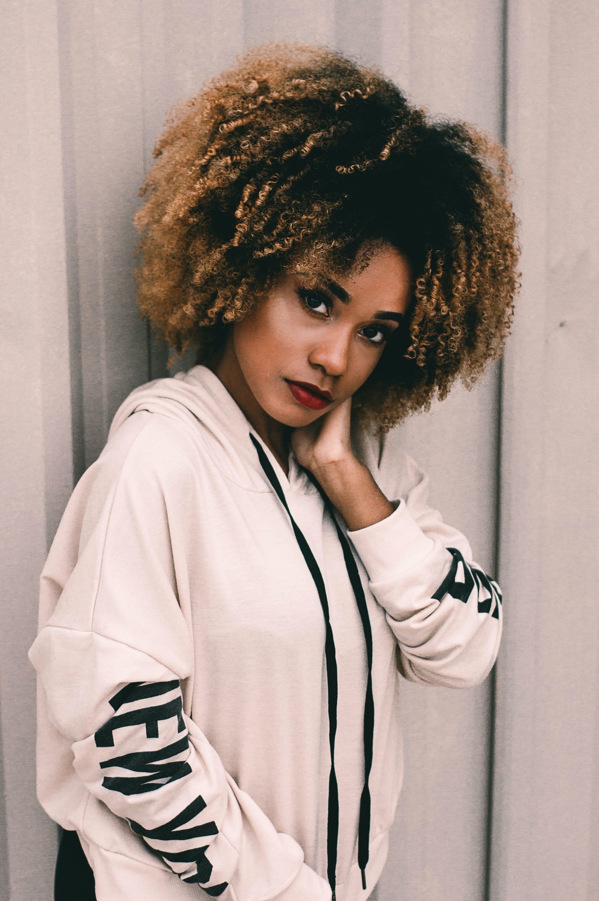 hair colours for winter: woman with caramel ombre natural curly hair