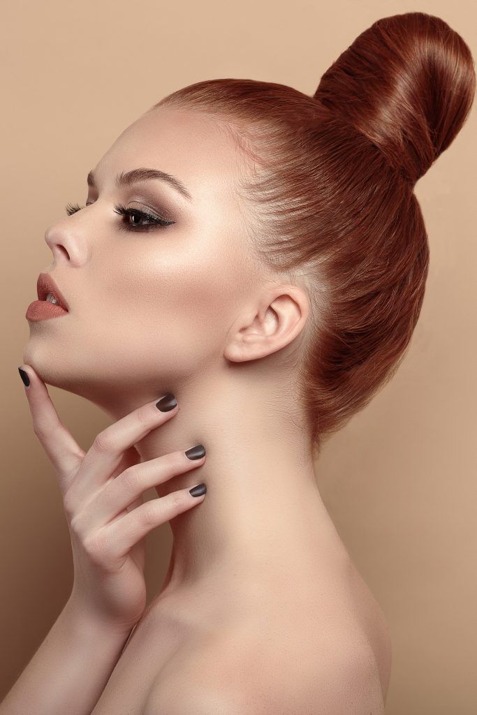 woman with red hair and a sleek high bun hairstyle