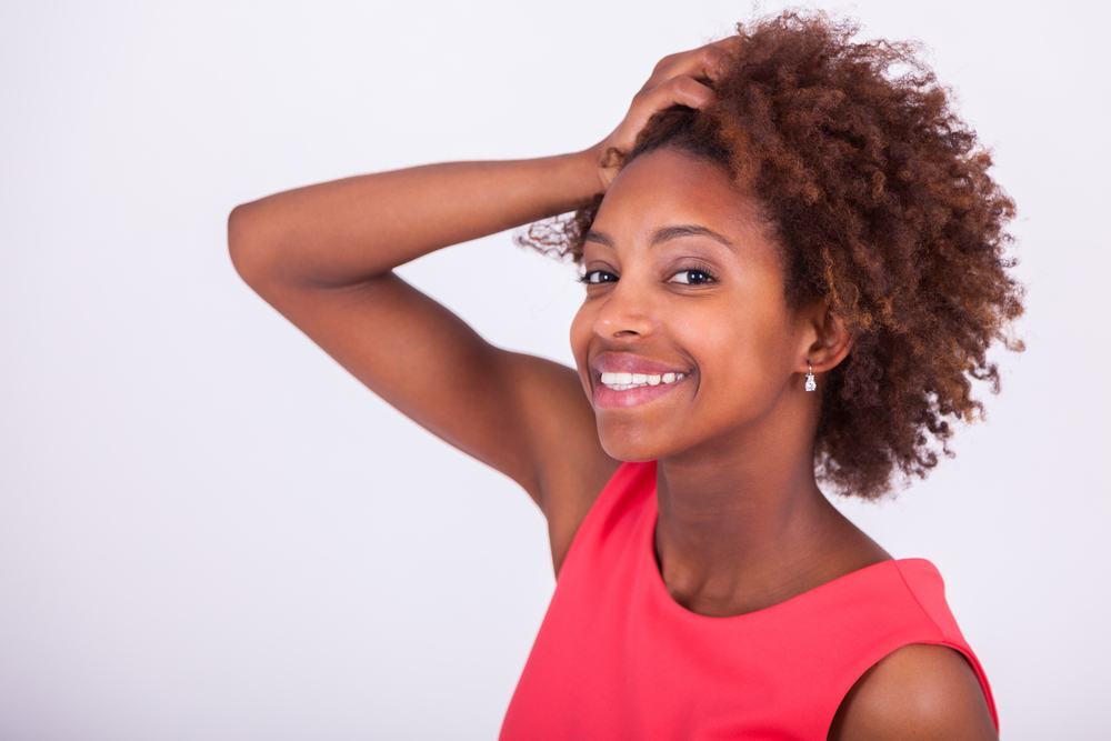 woman with her hand in her natural afro hair