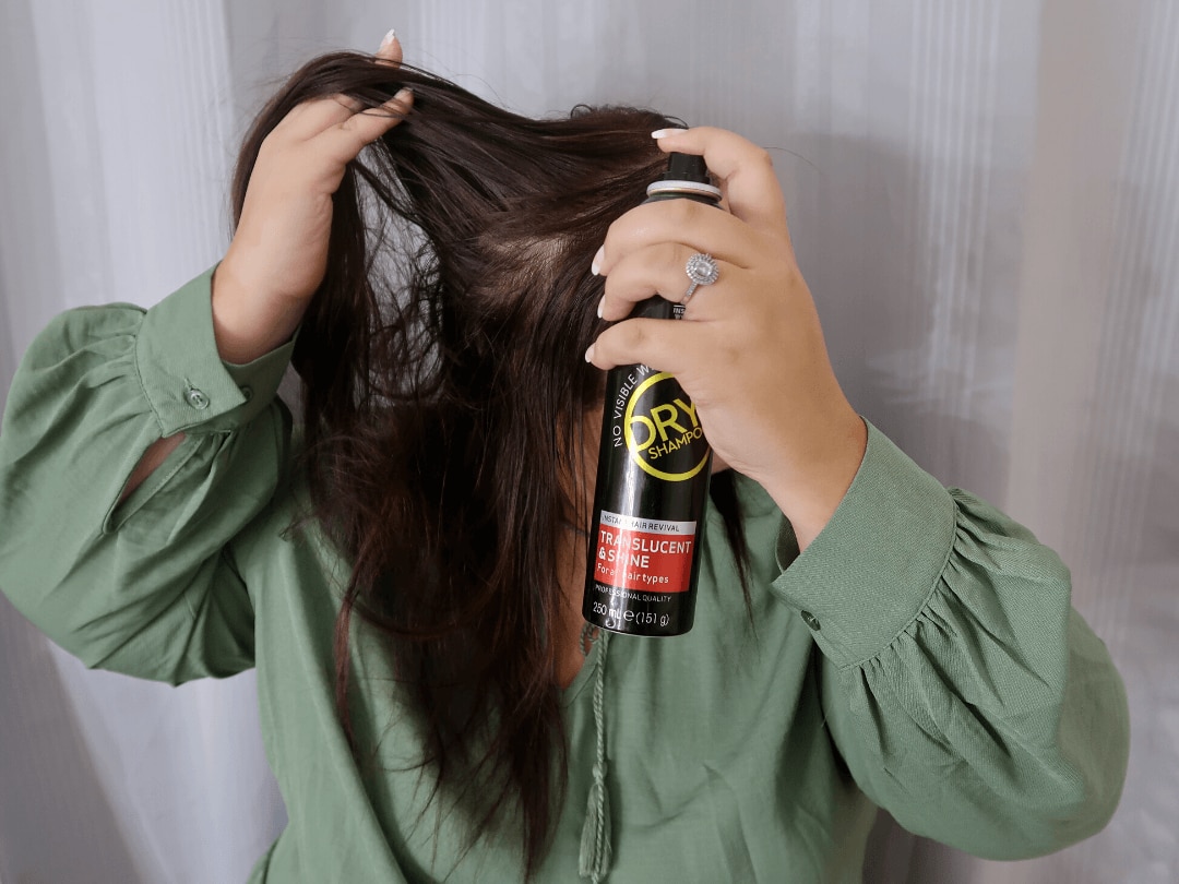 girl spraying dry shampoo