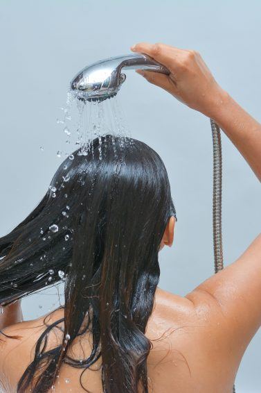 woman with wet hair and shower head