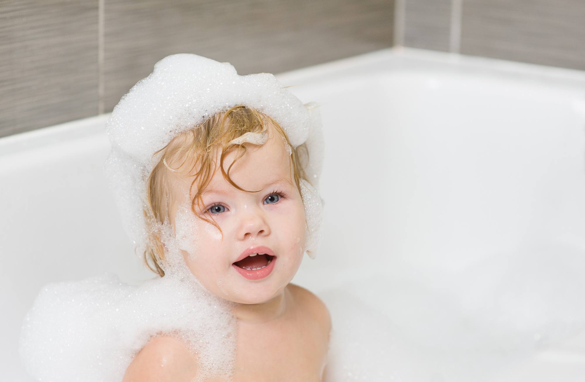 festive haircare for family: baby with wet hair in a bubble bath