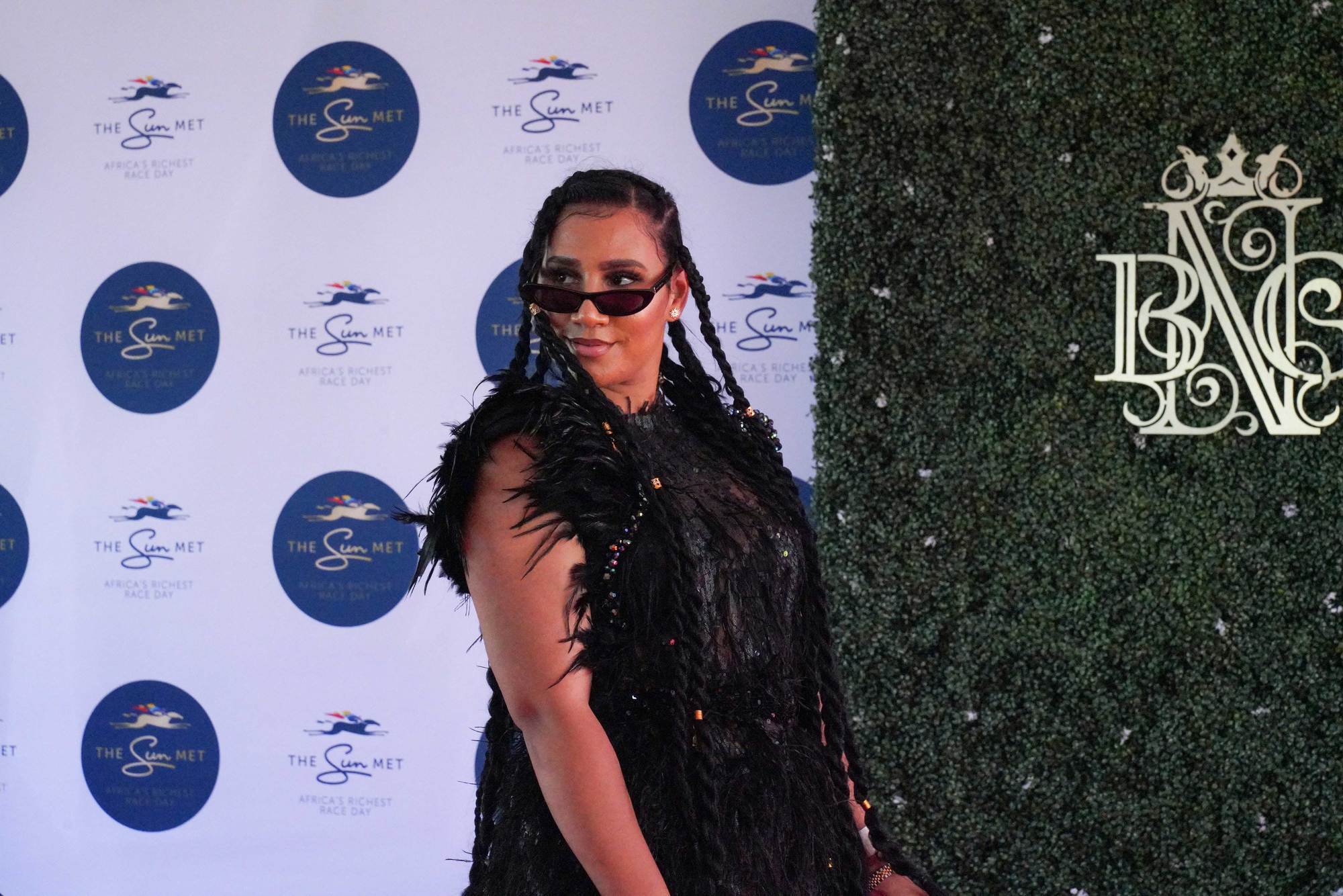 woman at the sun met 2020 with a full black outfit and long dramatic box twists and small accessories