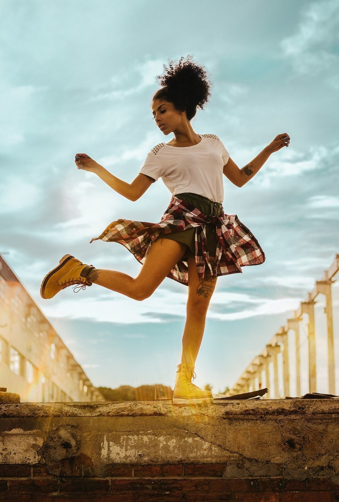 workout hairstyle: image of a woman dancing, with natural hair tied into a high puff hairstyle
