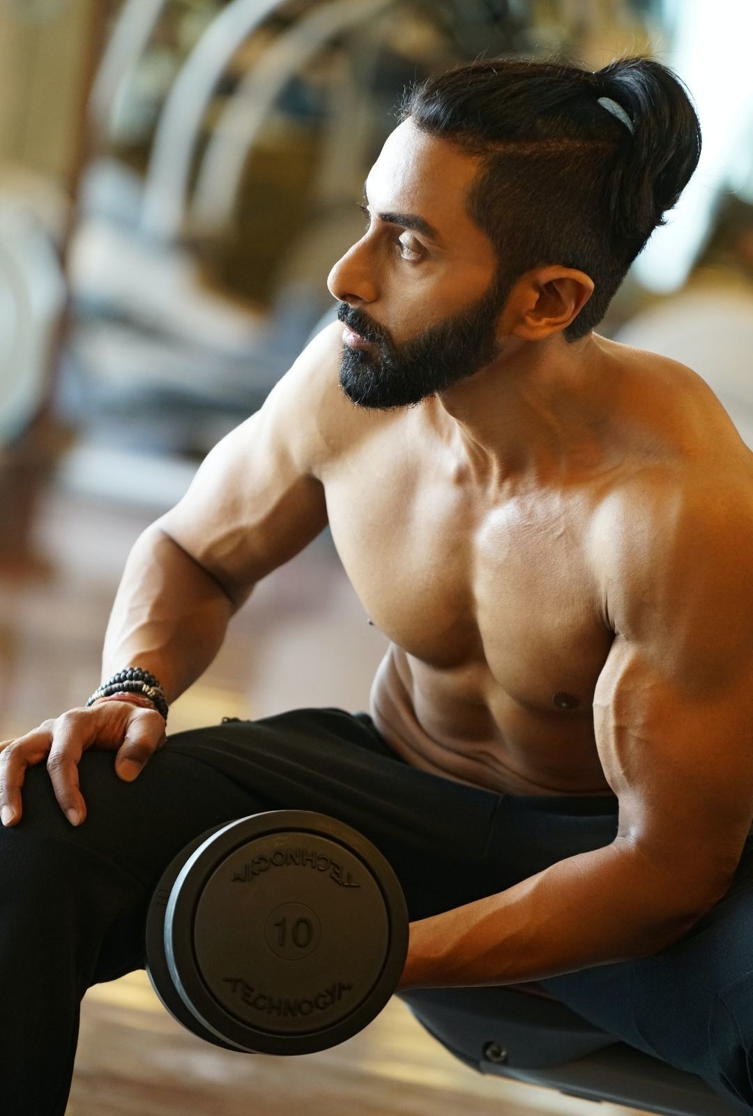 workout hairstyle: man lifting weights, with an undercut hairstyle and ponytail